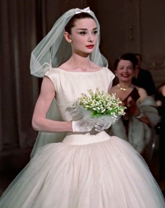 Audrey Hepburn dans sa robe de mariée portant un bouquet