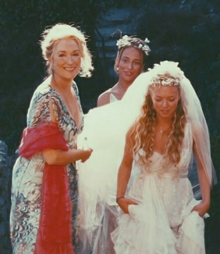 les actrices de mama mia toutes aidant la mariée à marcher avec sa robe et son voile de mariage