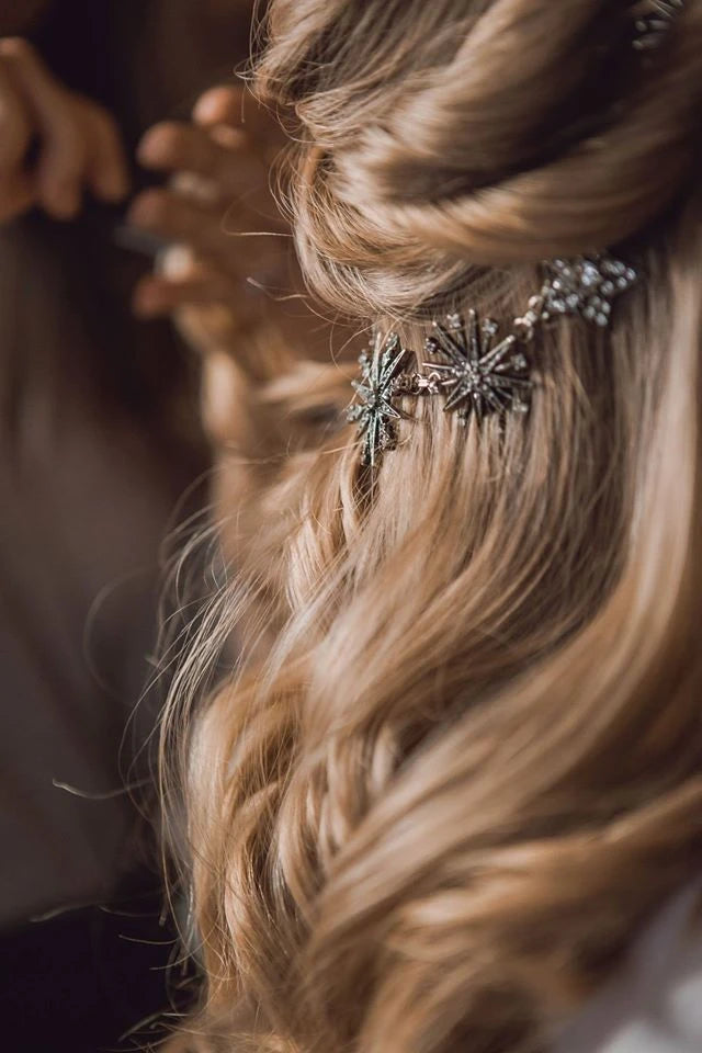 Focus sur les cheveux de la mariée hivernal avec une coiffure comportant une couronne d'étoiles vintage