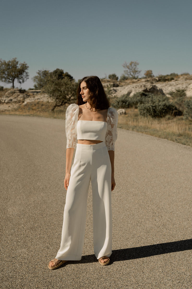 Femme dans un ensemble pour mariée avec un pantalon et un haut à manches bouffantes