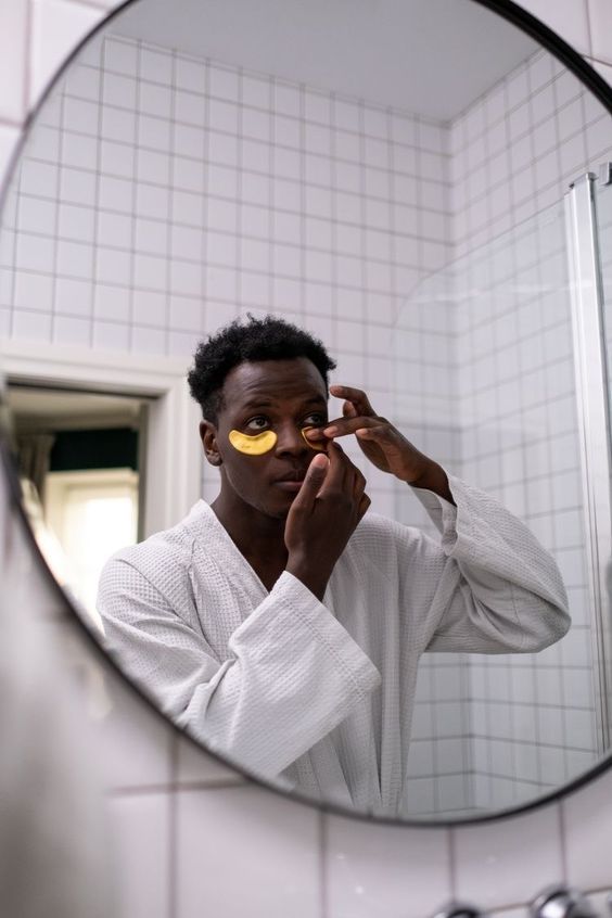 Un homme appliquant un soin du visage, quelques jours avant le mariage. Ce moment souligne l'importance des soins avant mariage et des habitudes de beauté dans sa routine, pour des mains et des ongles soignés et un look impeccable le jour J.