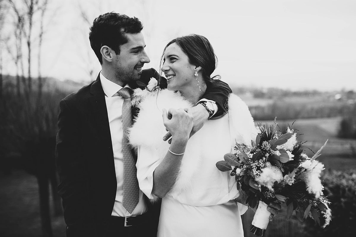 un couple de jeune mariés se regardant dans les yeux montrant pour la femme ses bijoux de mariage