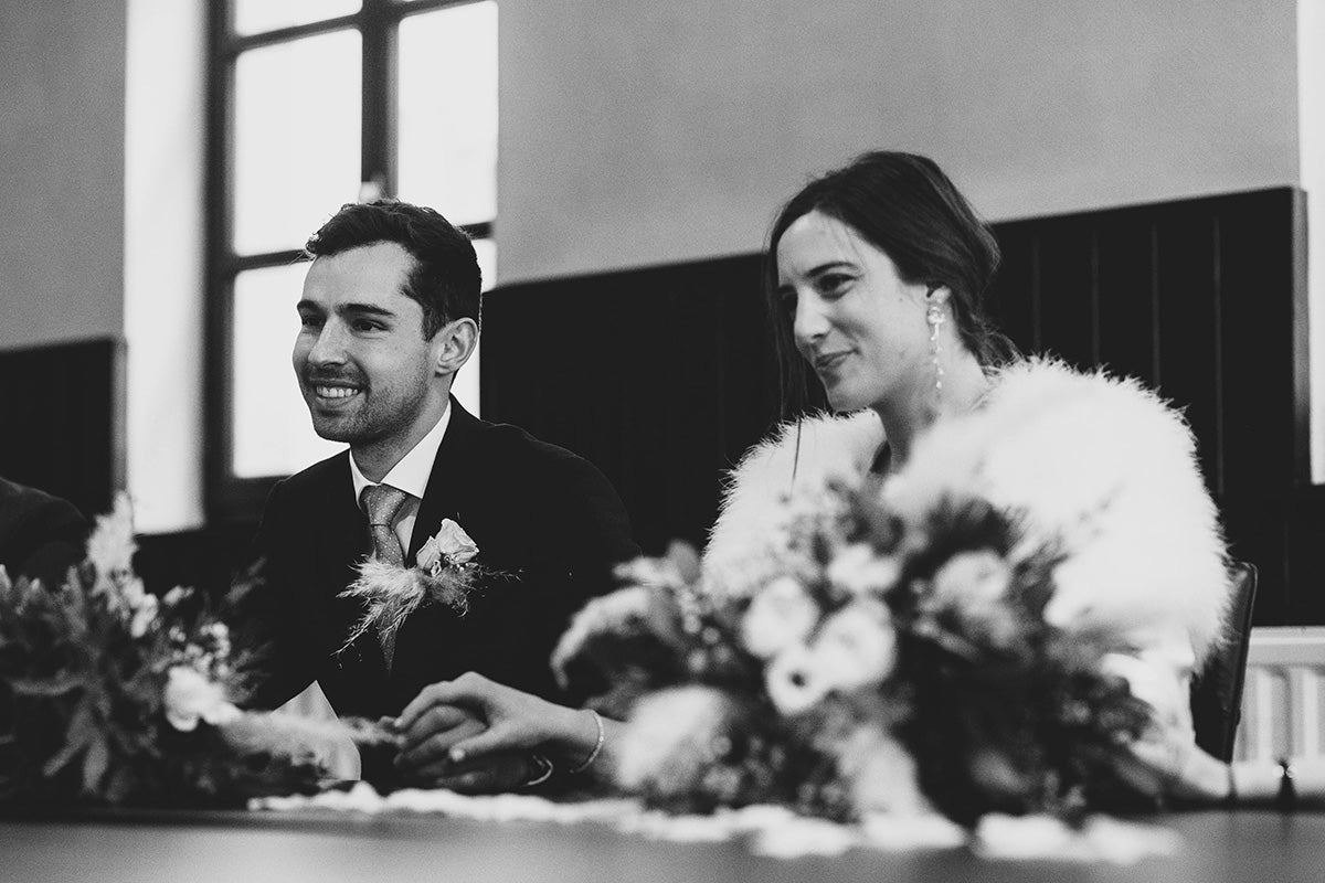 Le couple se tenant la main assis avec un grand sourire