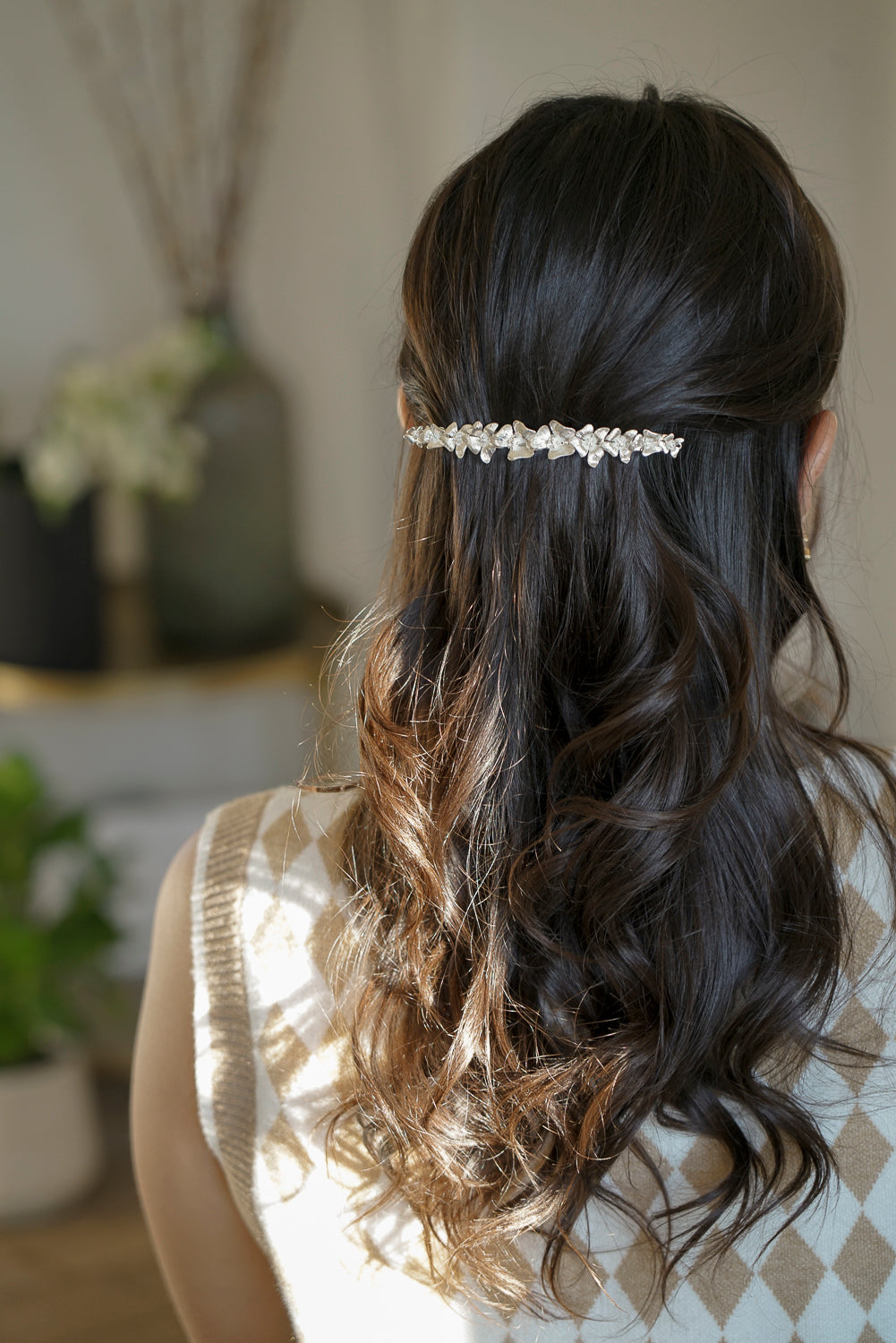 femme de dos portant une barrette de fleurs argentée 