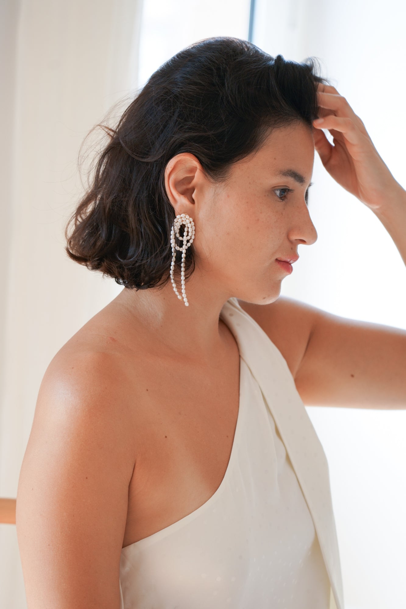 femme portant une robe blanche de mariée civil avec des boucles d'oreilles moderne en perles naturelles