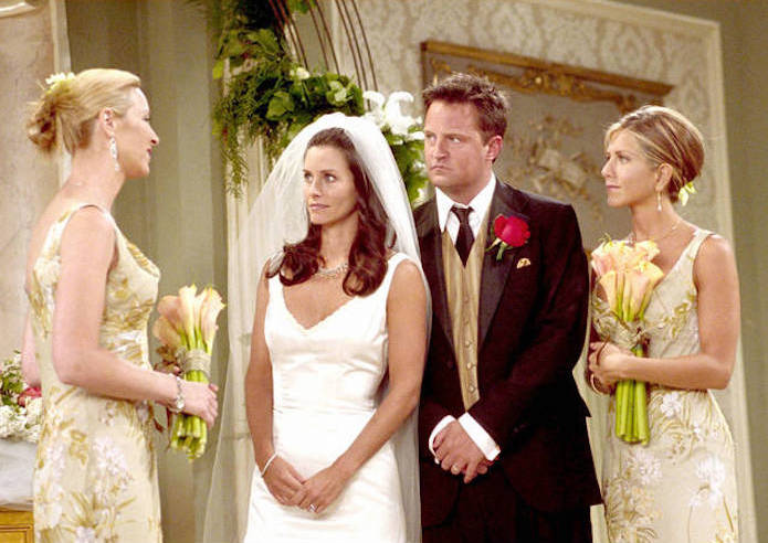 Les acteurs de friends écoutant l'une d'entre eux parler dans des tenues de mariage classique