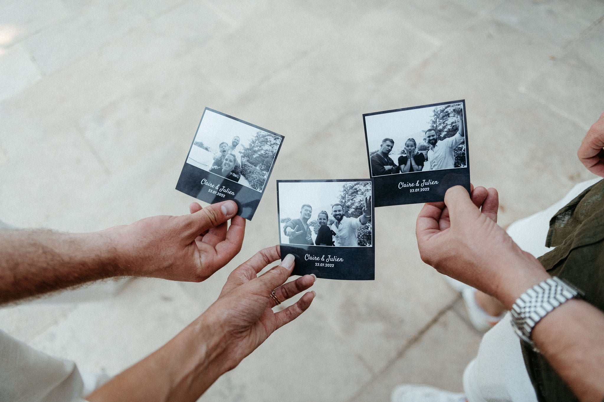 3 personnes qui tiennent dans leur main photos prise avec un photobooth lors d'un mariage 