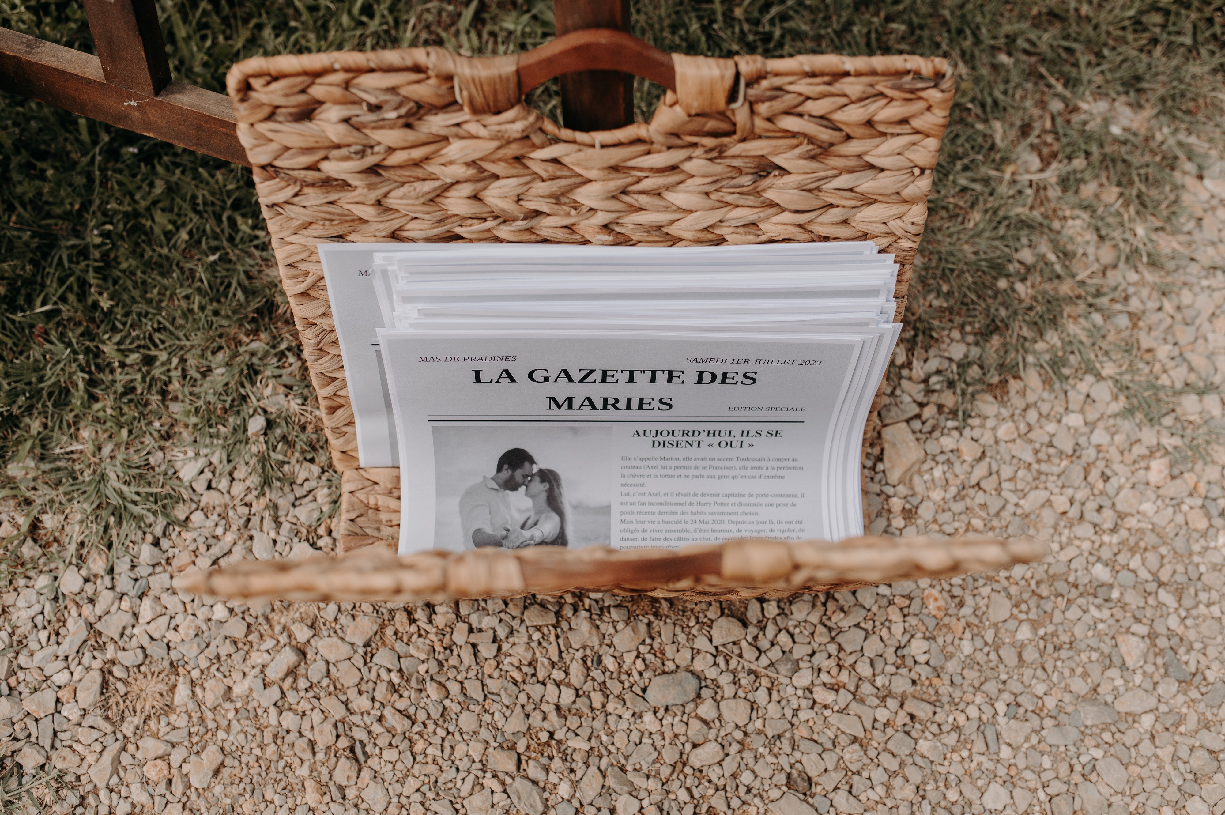 Petit porte journal en osier avec l'intérieur des exemplaires d'un journal parlant des mariés 