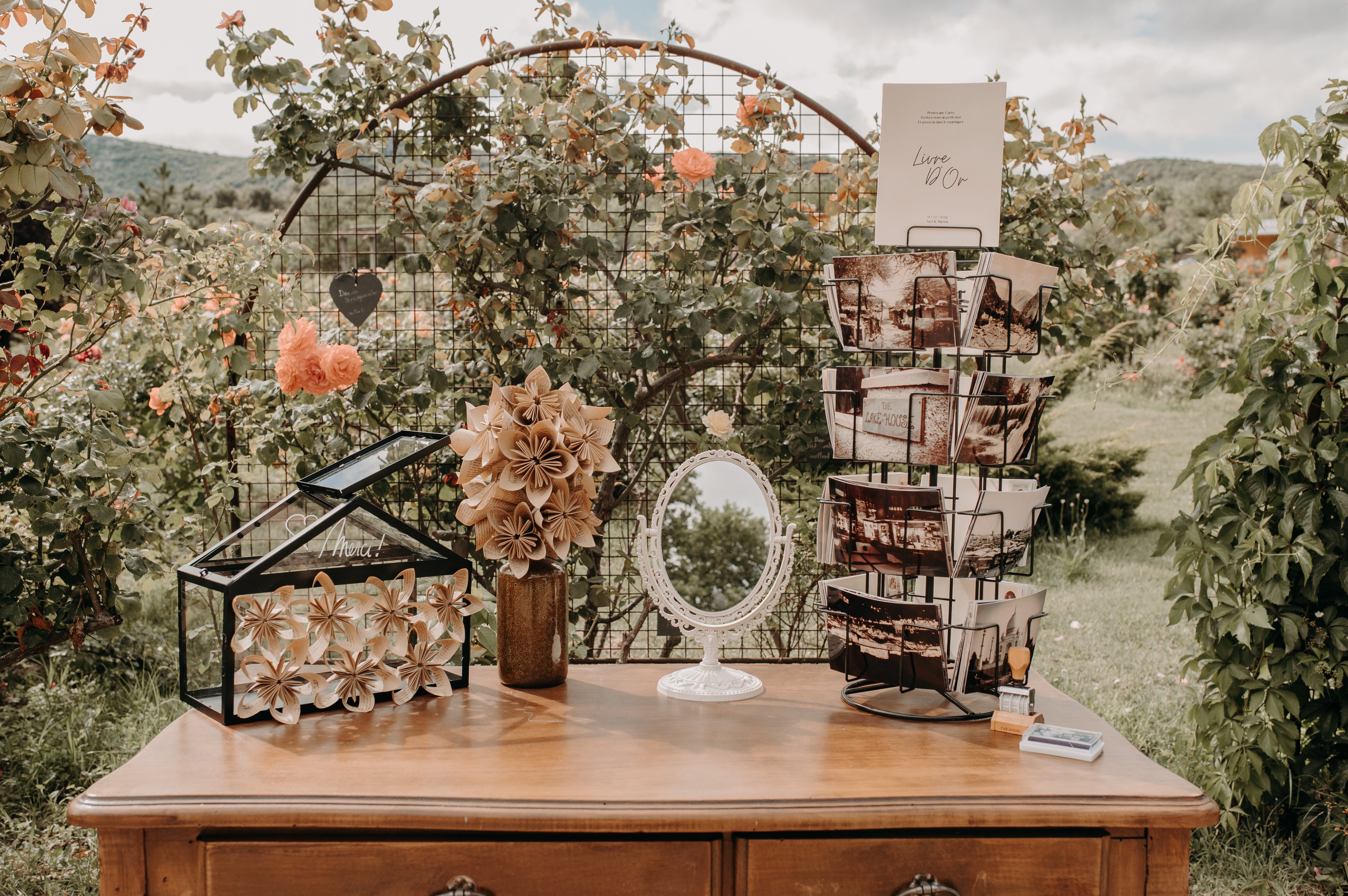 Meuble avec un espace livre d'or où les invités du mariage peuvent écrire sur une carte ainsi que des fleurs en papier