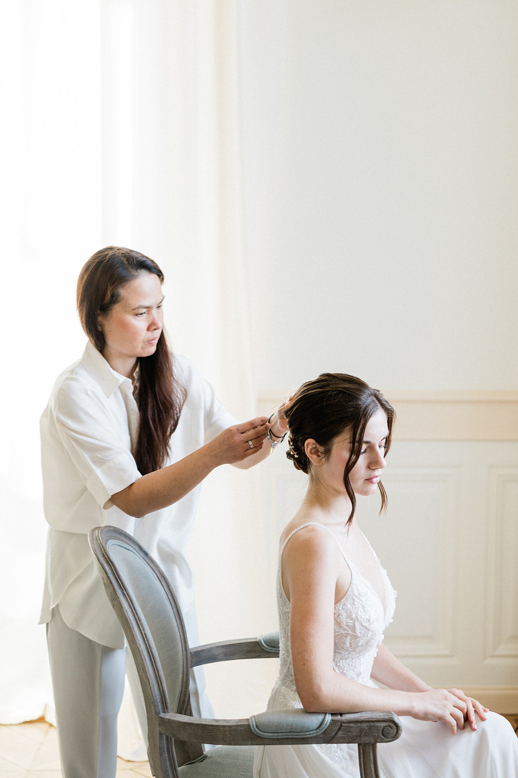 Une femme en train d'essayer son maquillage et sa coiffure de mariage, quelques jours avant le grand jour. Un moment doux et délicat, mettant en valeur ses mains soignées et ses ongles impeccables dans une belle routine de soins.