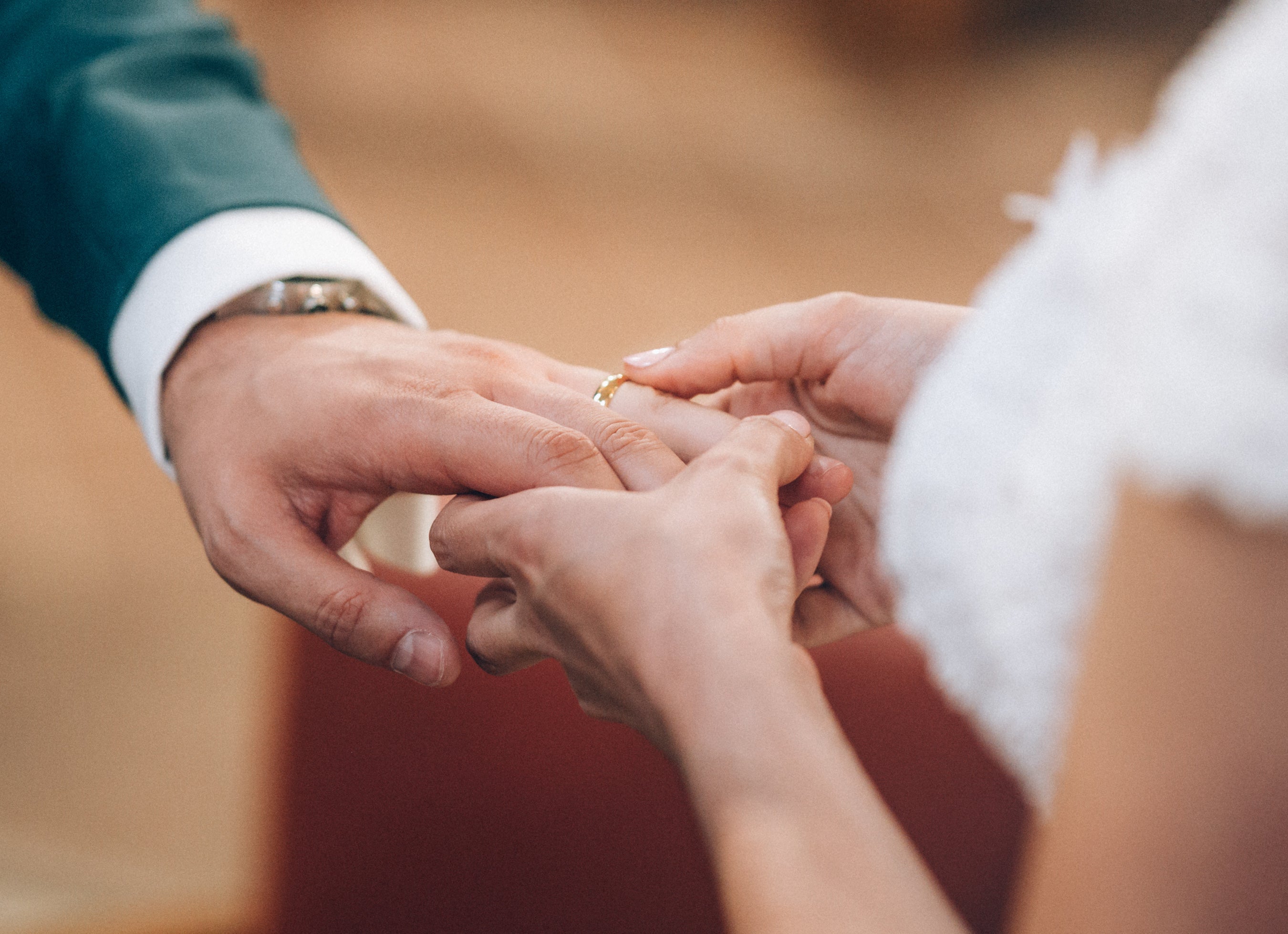 gros plan sur les mains du mari avec la femme qui lui met sa bague de mariage