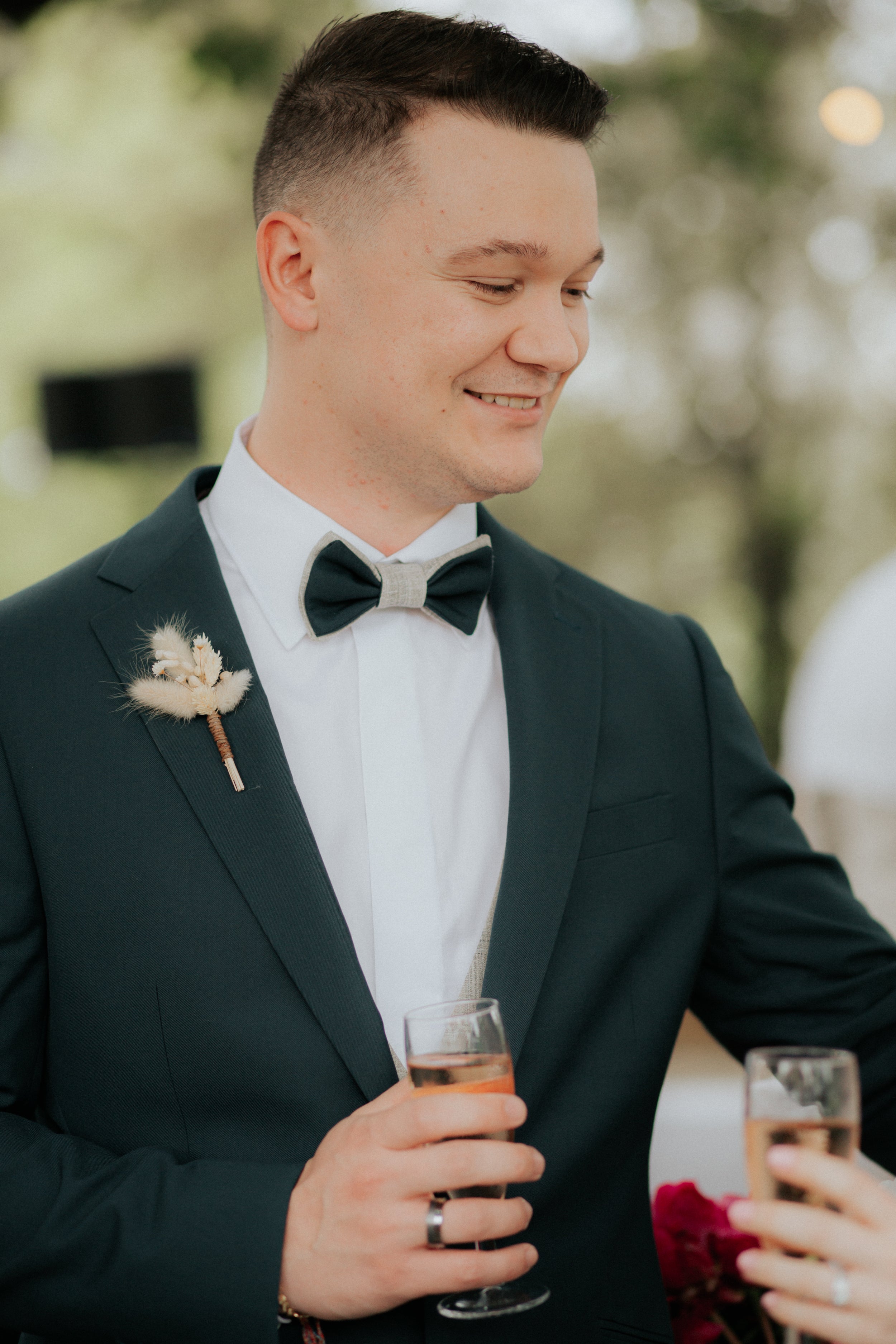 Le marié souriant en regardant sa femme en tenant une coupe de champagne dans sa main