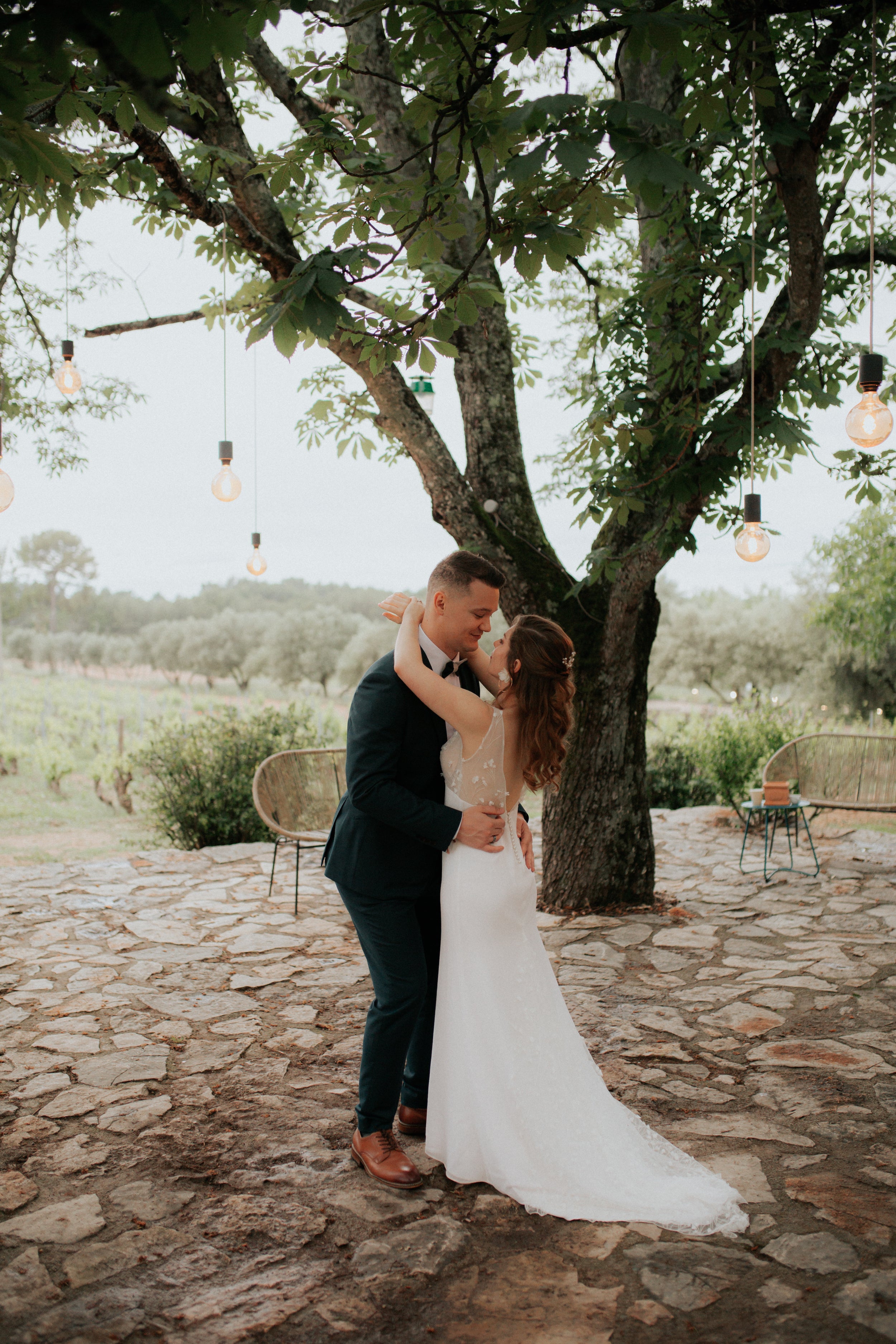 Les mariés qui dansent à l'extérieur en tenues de mariage