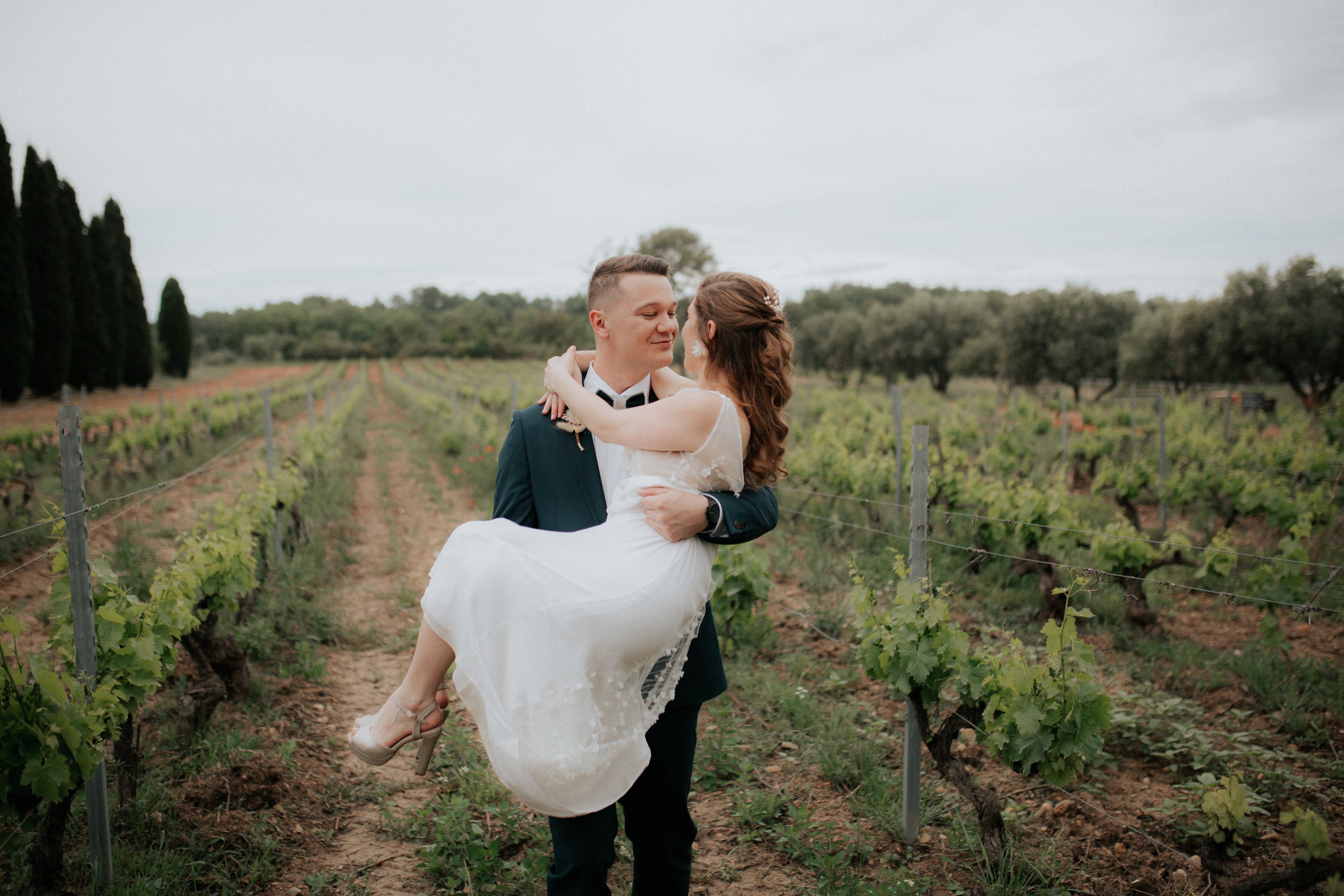 Le marié portant sa femme à l'extérieur le jour de leurs mariage