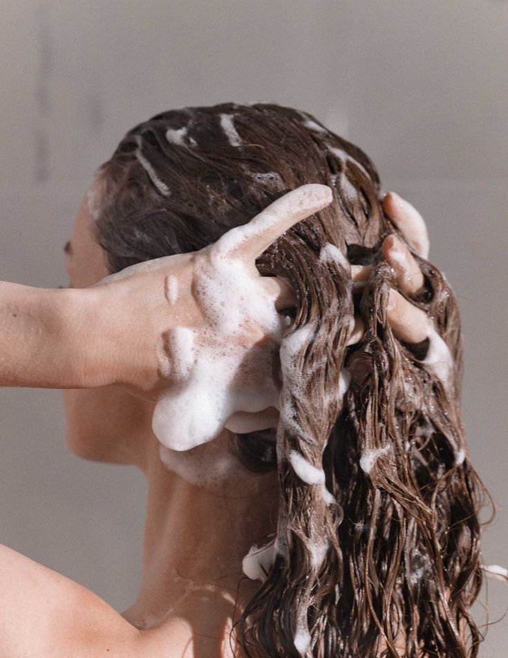 Une mariéeappliquant un soin capillaire, quelques jours avant son mariage. Ce moment doux fait partie de sa routine de soins avant mariage, soulignant l'importance de chouchouter ses cheveux pour un look éclatant le jour J.