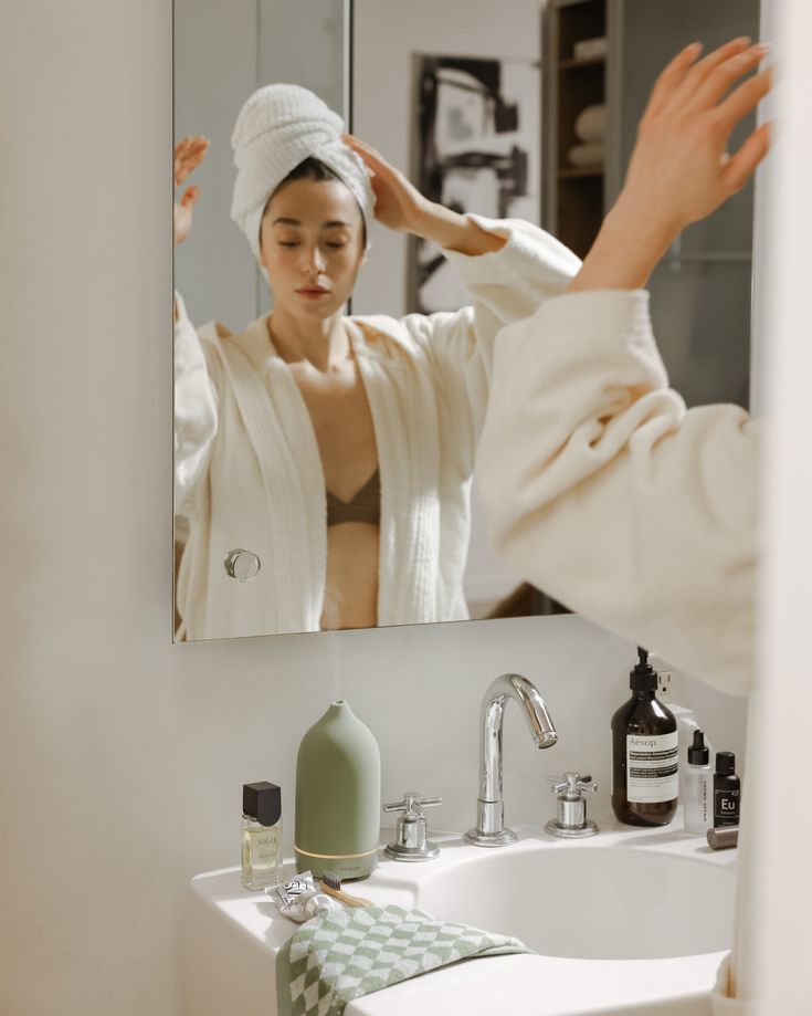 Une femme en train de réaliser sa routine beauté avant le mariage, appliquant délicatement son maquillage de mariée. Ses mains soignées sont mises en valeur, et ses ongles impeccables complètent ce moment de préparation. Cette étape fait partie des soins indispensables à effectuer quelques jours avant le grand jour pour un éclat parfait. Conseils beauté et bonnes habitudes sont au rendez-vous pour une mise en beauté réussie.