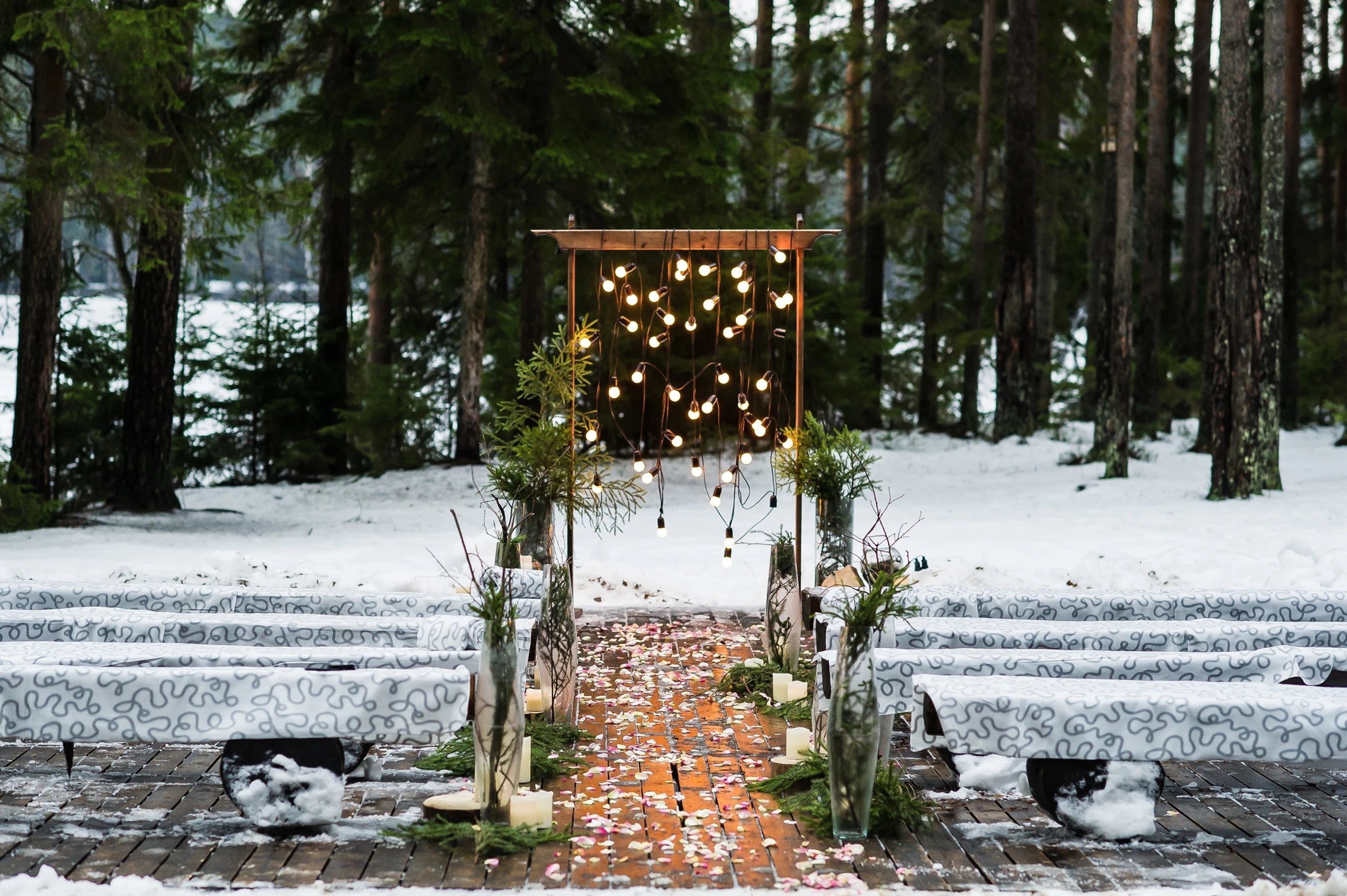 Lieu de cérémonie pour l'hiver à l'extérieur avec des guirlandes lumineuses et des bancs enneigés