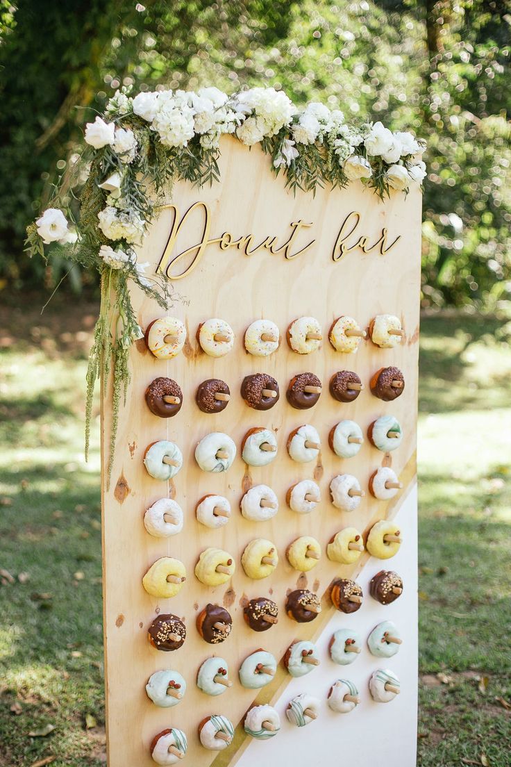 planche de bois avec des donuts accrochés sur des pics en bois pour une animation mariage