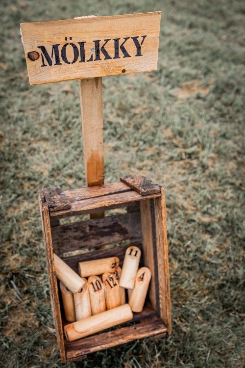 jeu en bois écrit molkky posé dans l'herbe pour une animation mariage