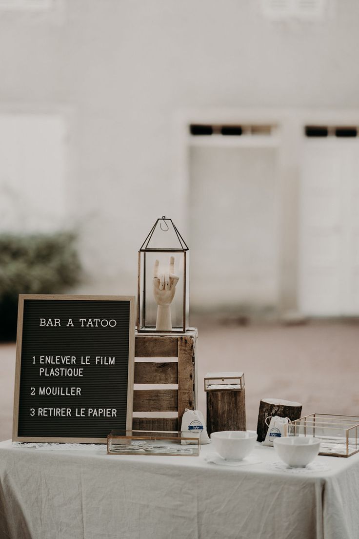 table avec une nappe en lin et un tableau noir 'dcrit bar à tatoo pour un animation de mariage