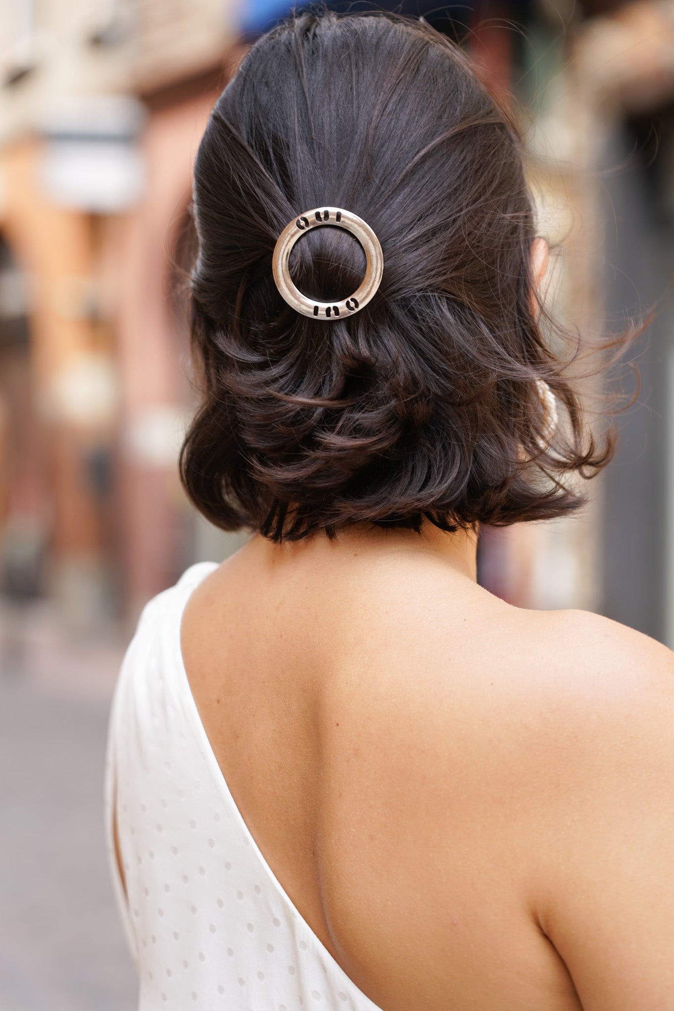 Femme de dos avec les cheveux courts montrant son bijou de cheveux de mariage oui