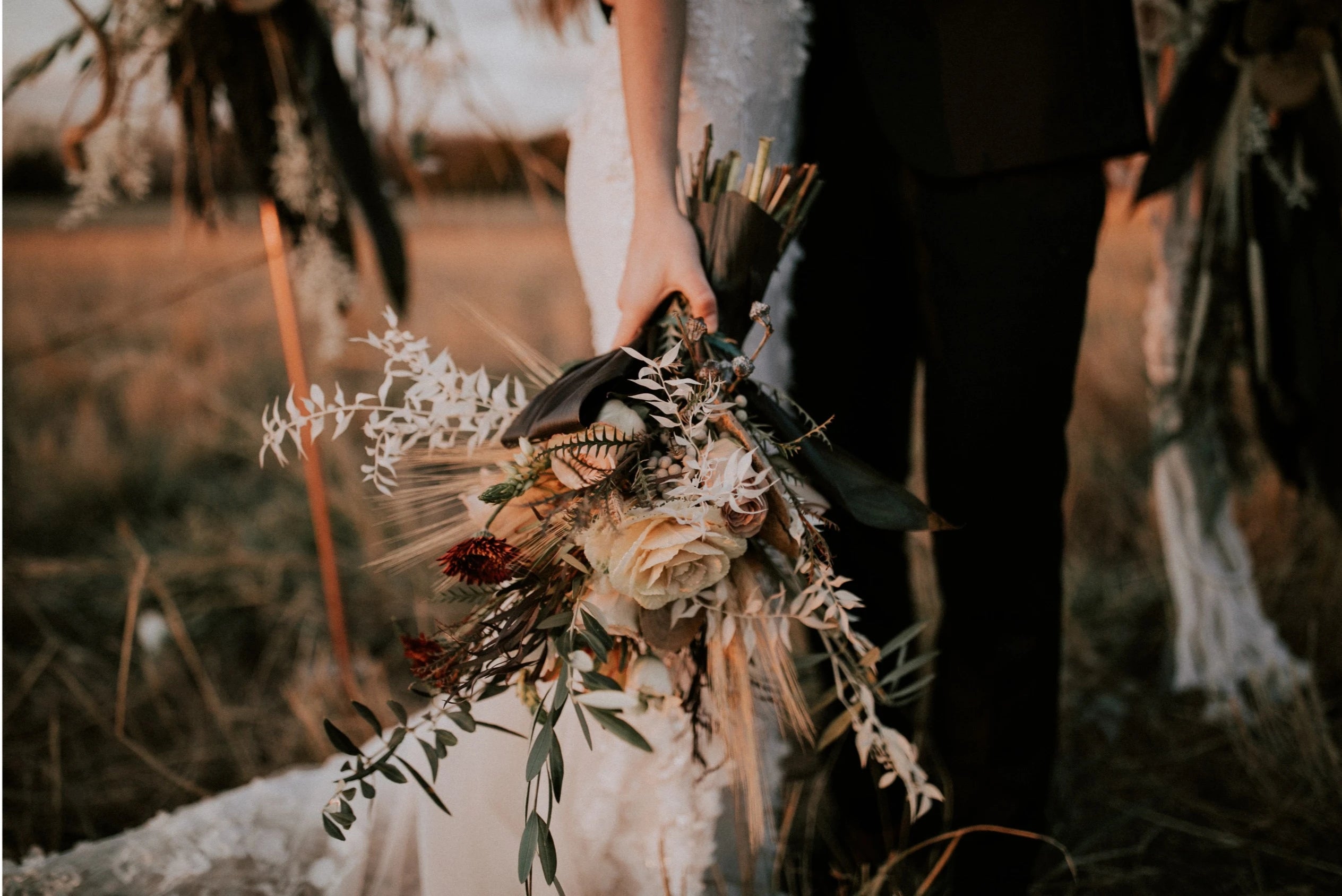 Focus sur le bouquet de fleurs séchées de la mariées pendant la cérémonie en extérieur 