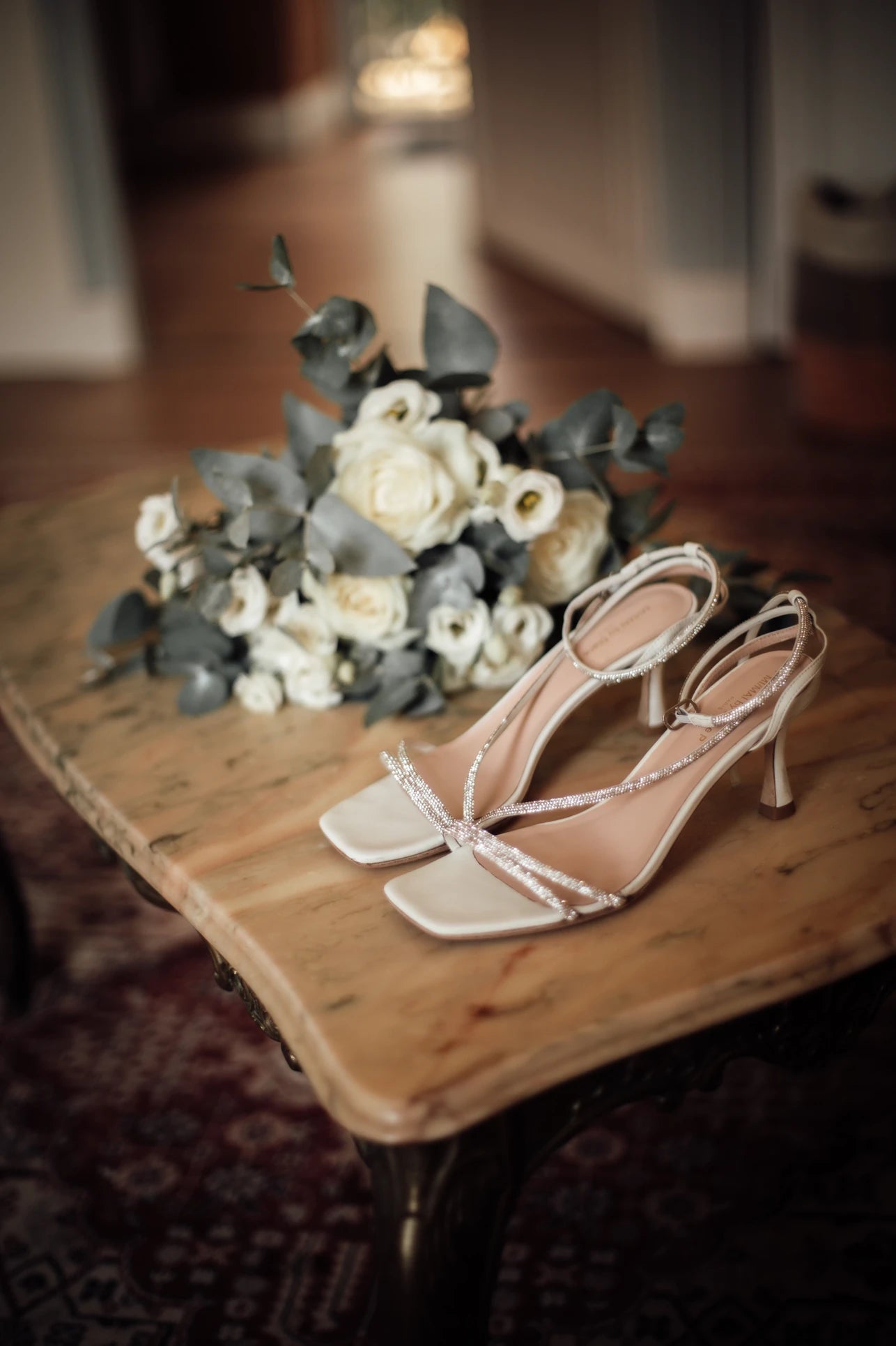 Gros plan sur les chaussures à talons de la mariée et le bouquet de mariage