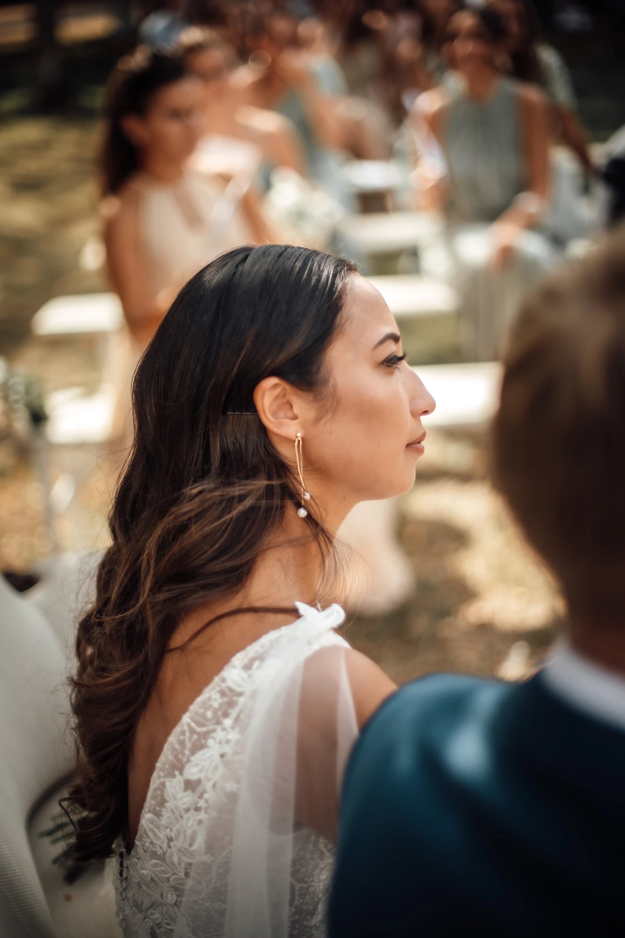 femme de profil concentrée montrant ces bijoux de mariage raffinés