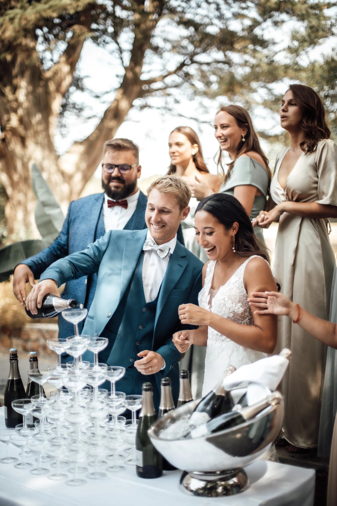 Le marié servant le champagne avec autour de lui la mariée et les demoiselles d'honneurs