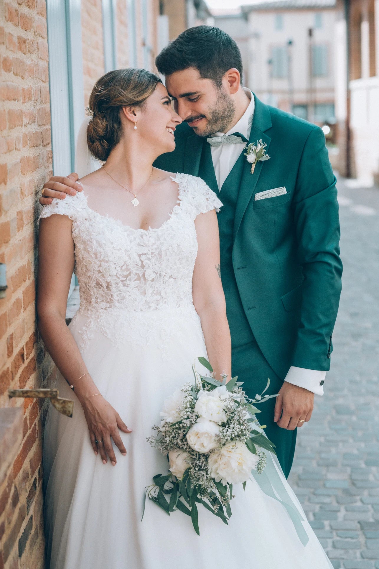 Couple de mariés qui se regardent dans les yeux dans leurs tenues de mariage et accessoires pour cérémonie