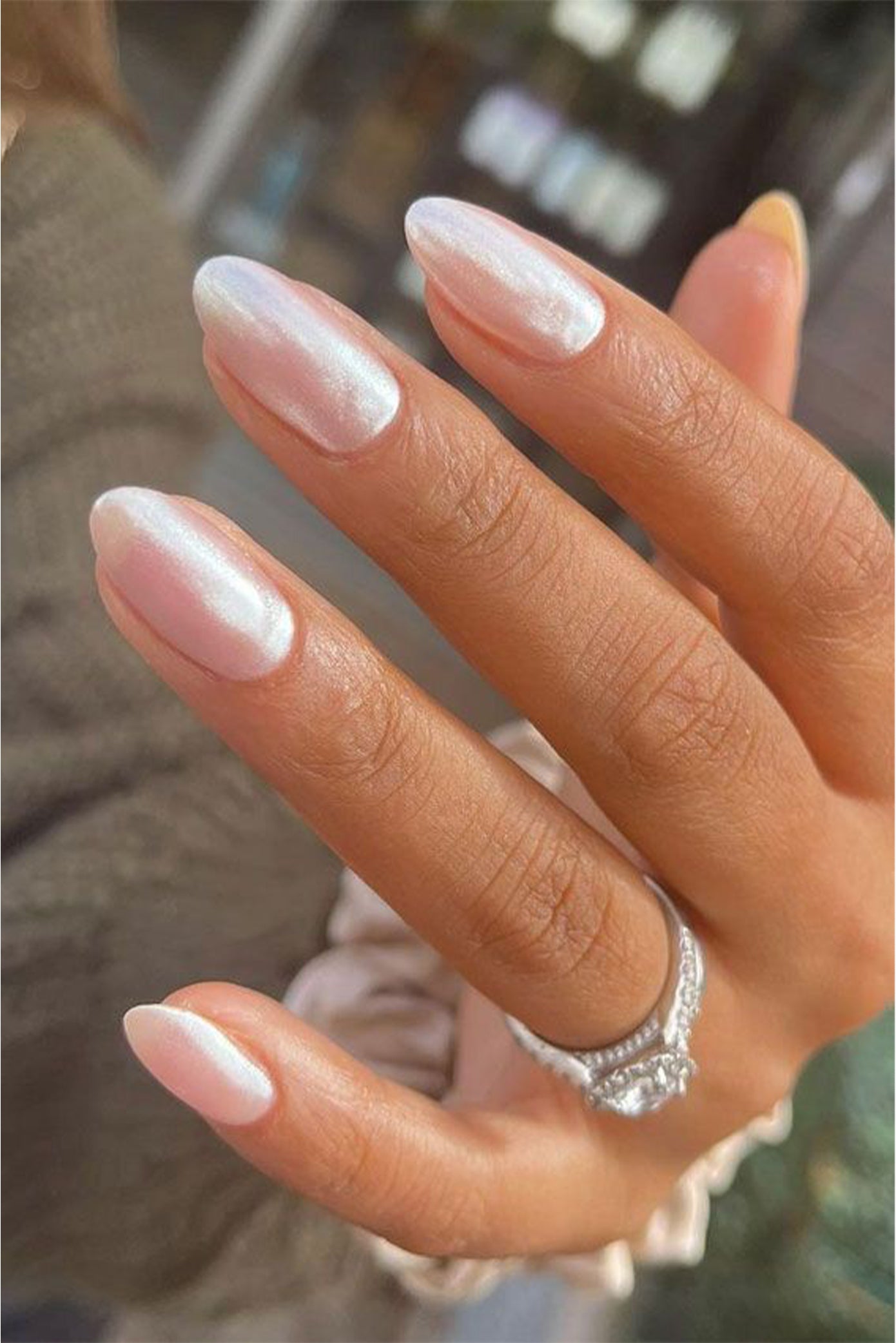 Gros plan sur les ongles d'une mariée avec un style nacré et une forme en amande