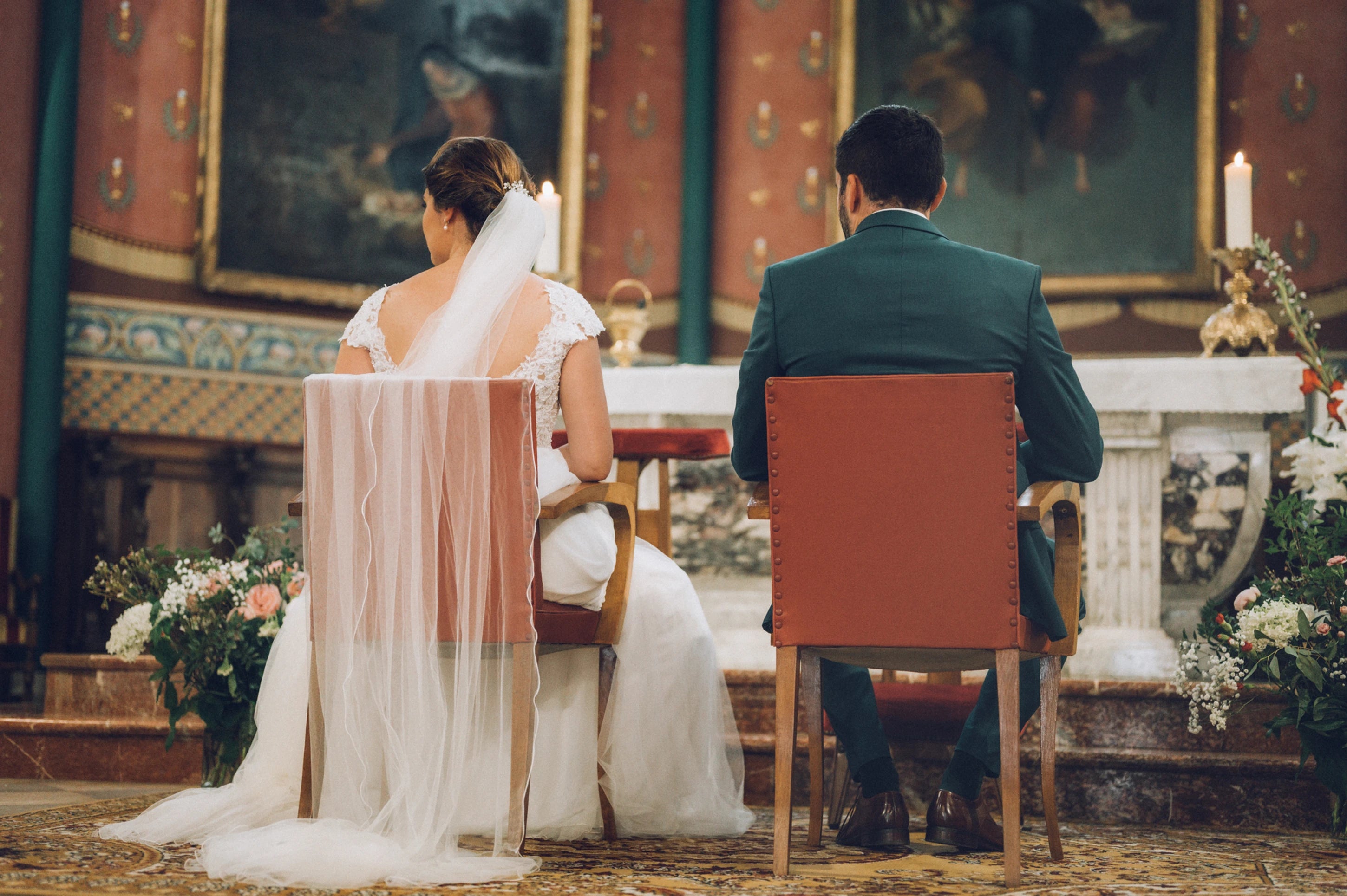 Les mariés dans l'église assis sur une chaise attendant le début de célébration religieuse