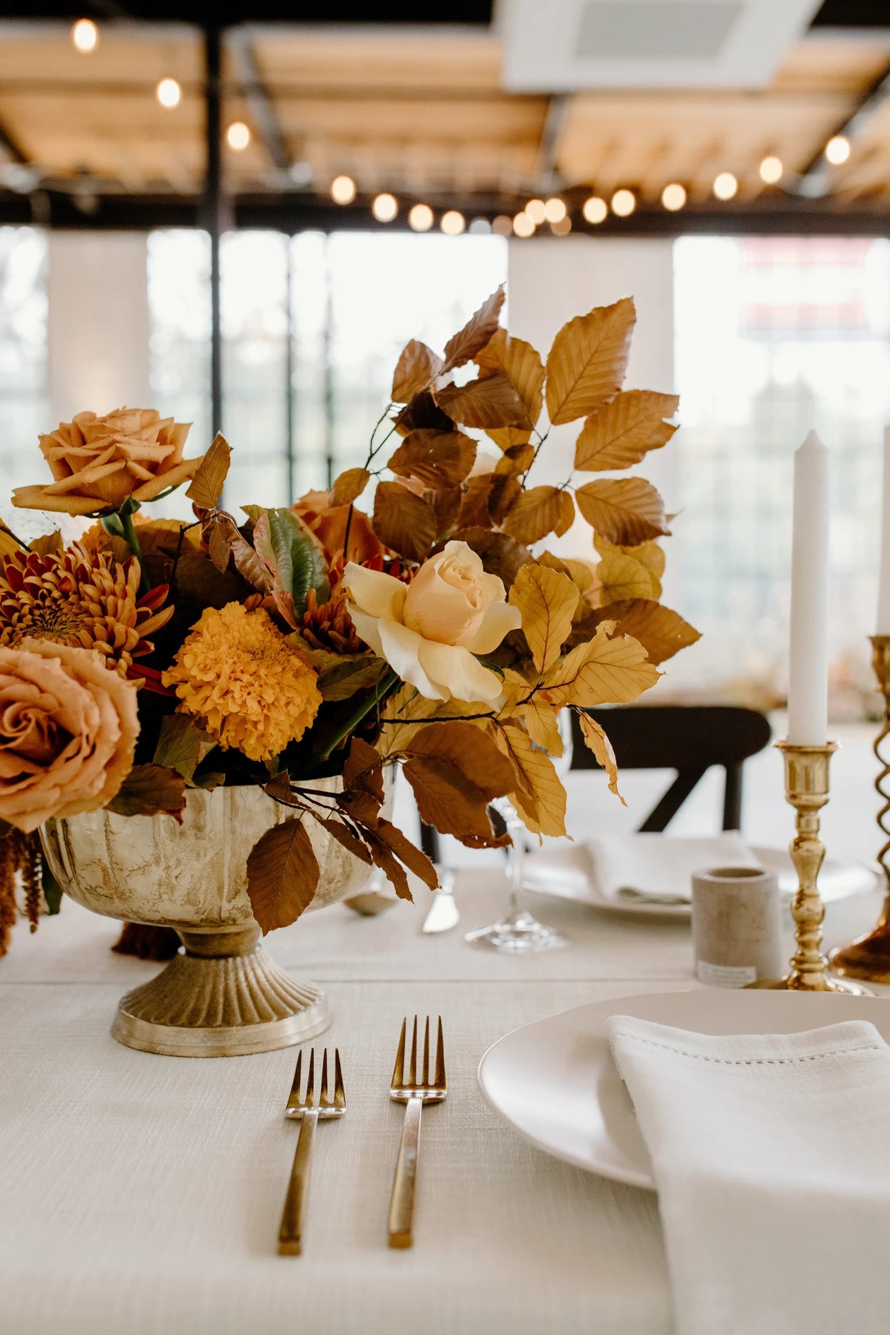 Centre de table de cérémonie comportant un vase et un bouquet de fleurs automnal