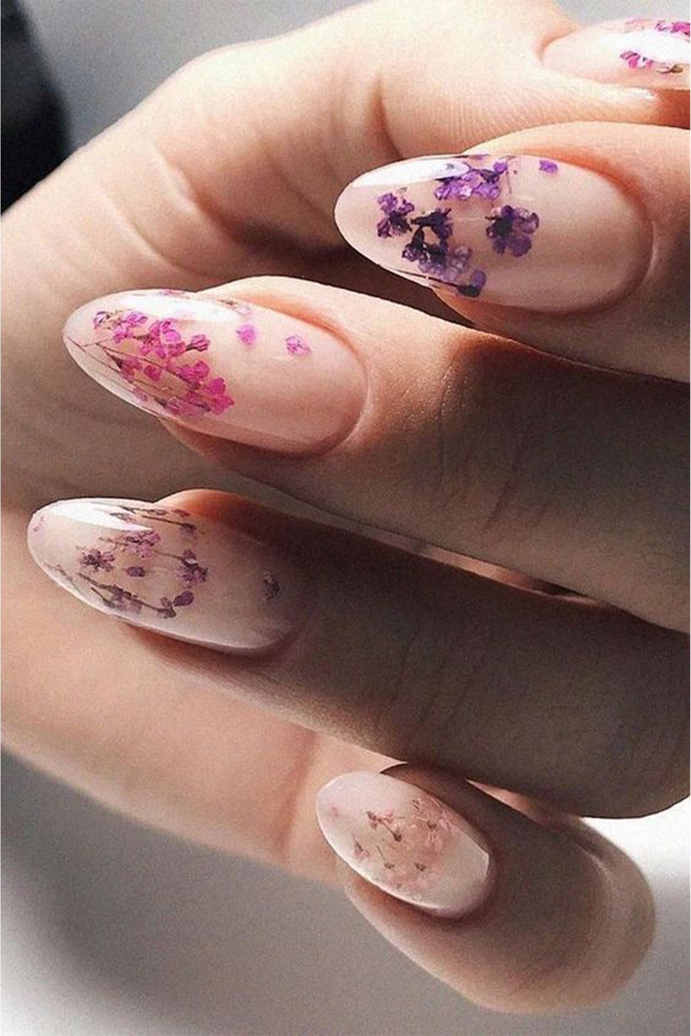 Ongles long  pour mariée avec des fleurs incrustées dans la manucure de couleur rose ou violette