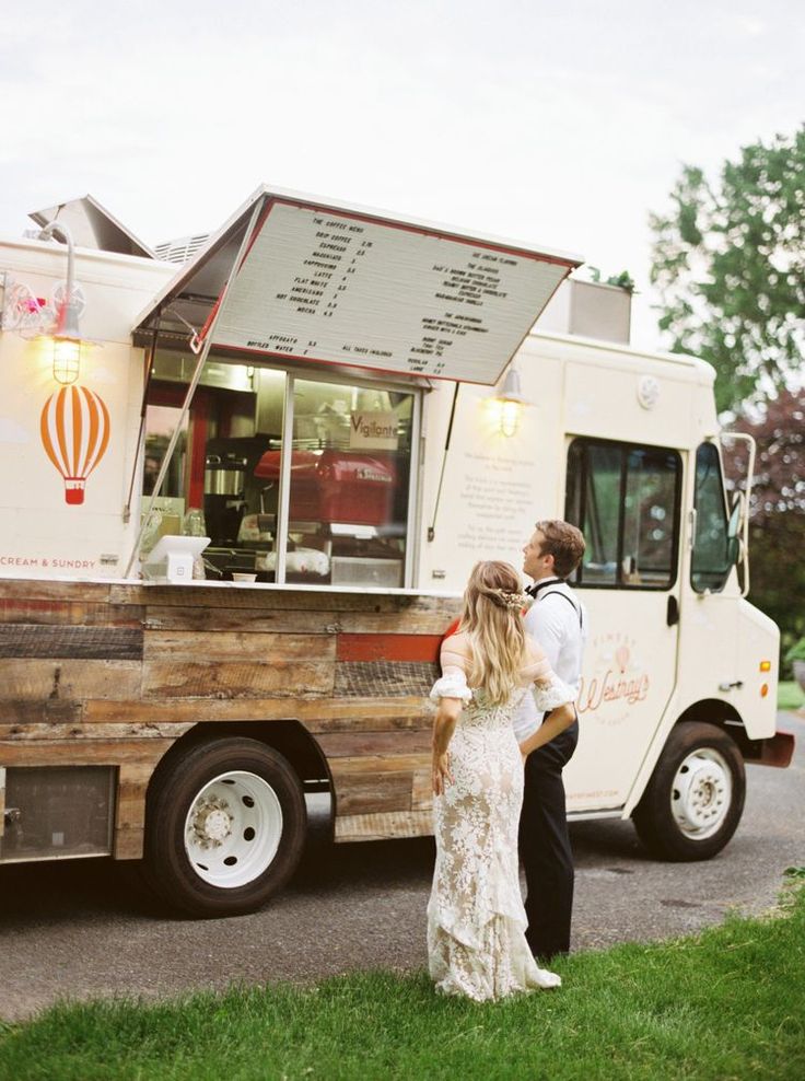 couple de marié entrain de regarder un foodtruck blanc lord du leur mariage