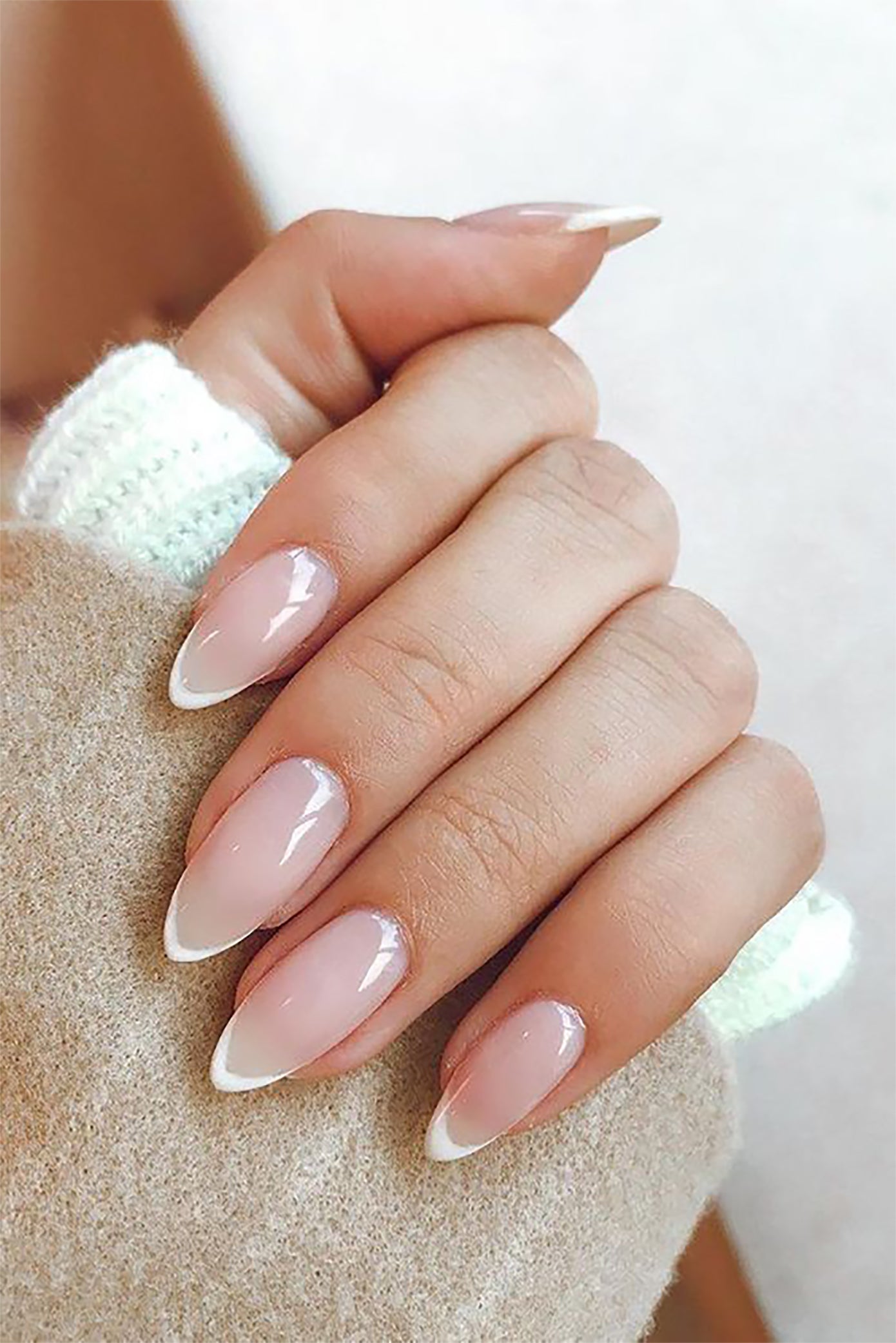 Gros plan sur la main d'une mariée avec un vernis style french manucure