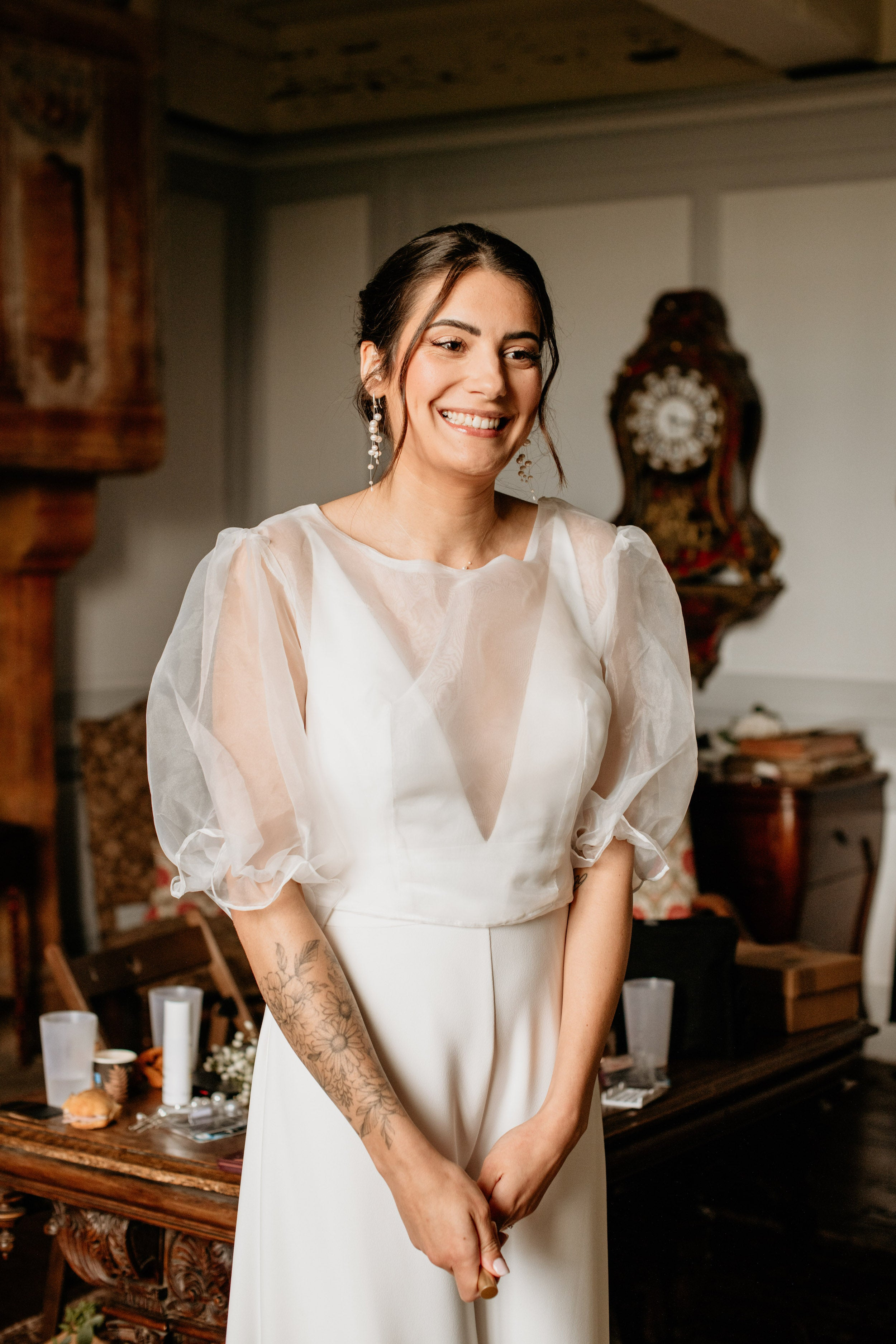 Femme souriante portant son ensemble de mariage et ces bijoux pour mariée