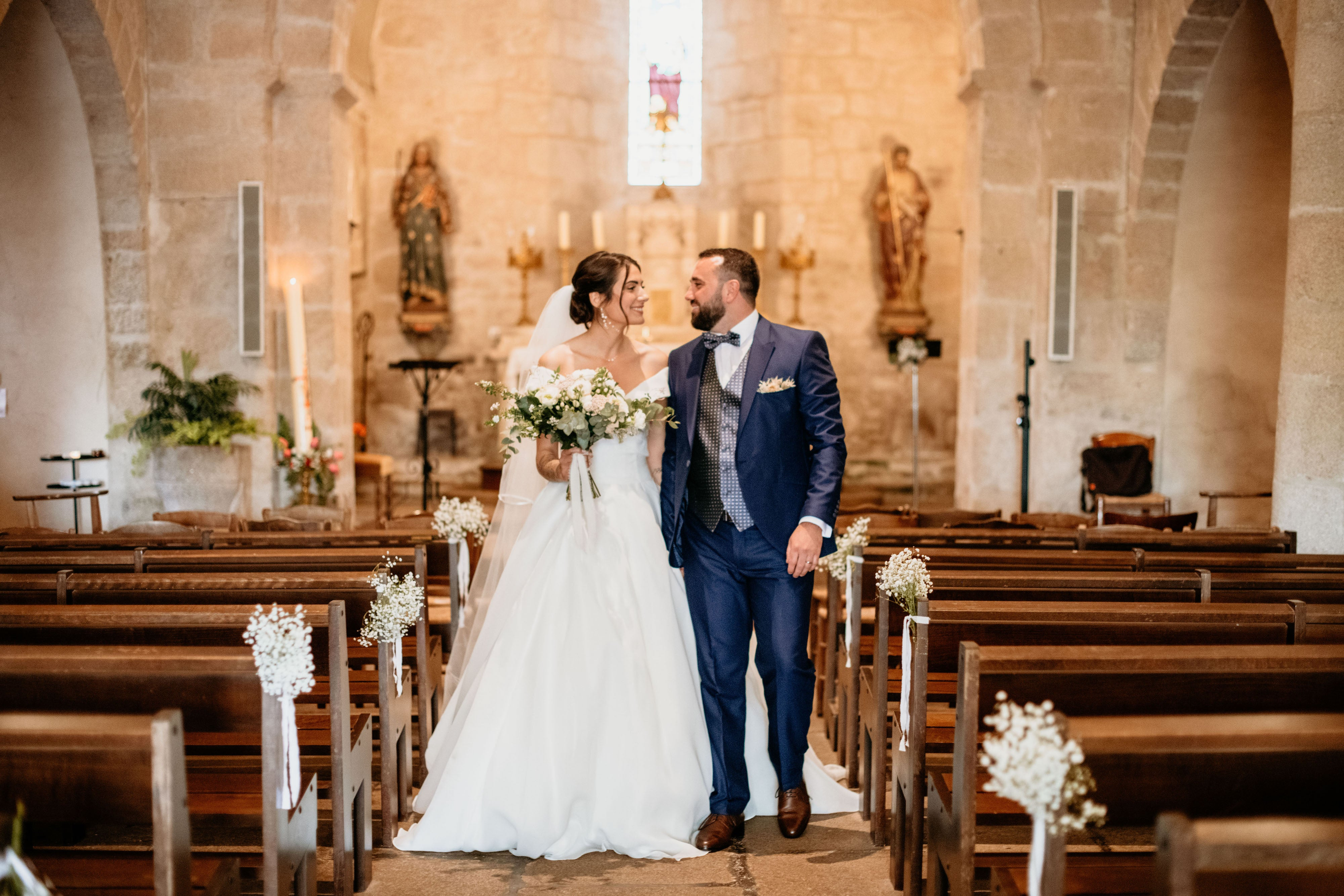 Deux mariés marchant dans l'église en ce regardant ce qui montre leurs accessoires de mariage