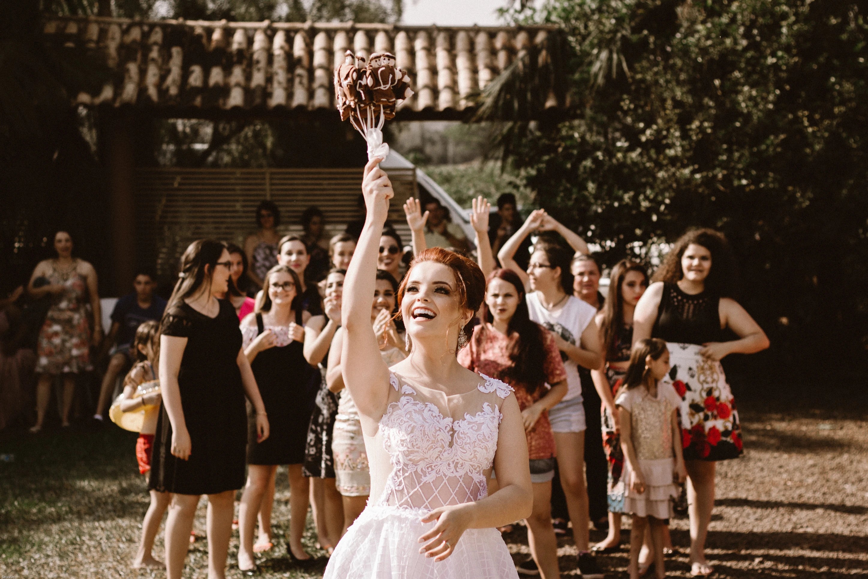 Jeune mariée qui lance son bouquet de fleur en chocolat pour les invités 