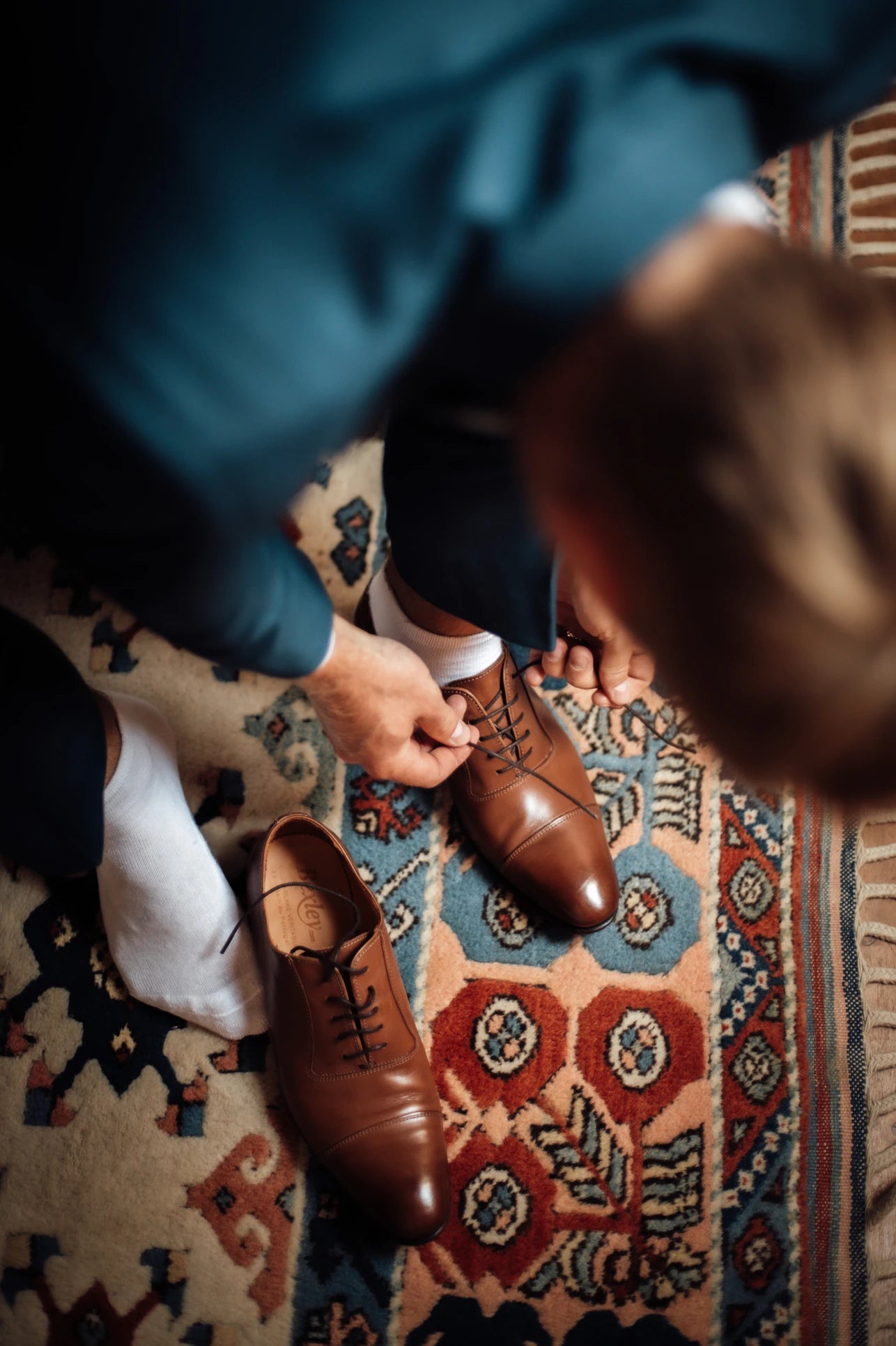 Jeune homme qui lasse ses chaussures de fête