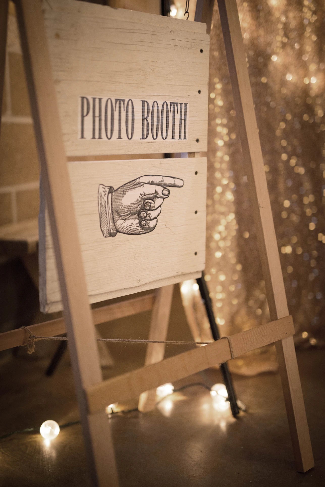 Écriteau avec une inscription et un dessin pointant vers le photo booth des mariés