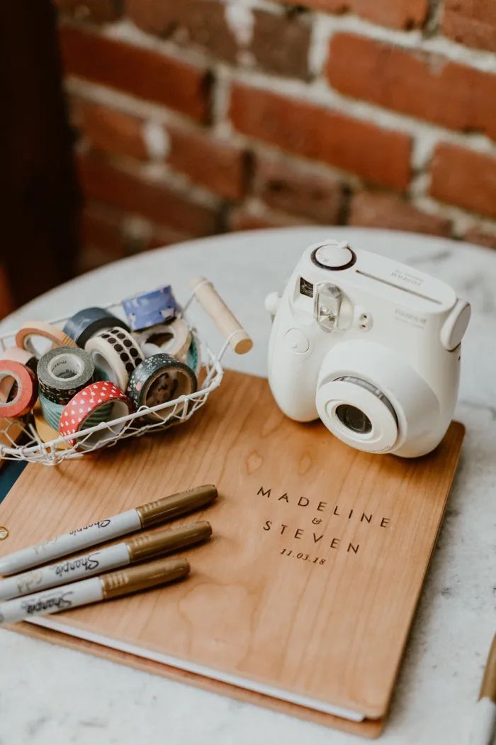 livre d'ore de mariage en bois avec des feutres et un appareil photo instantané pour une animation mariage