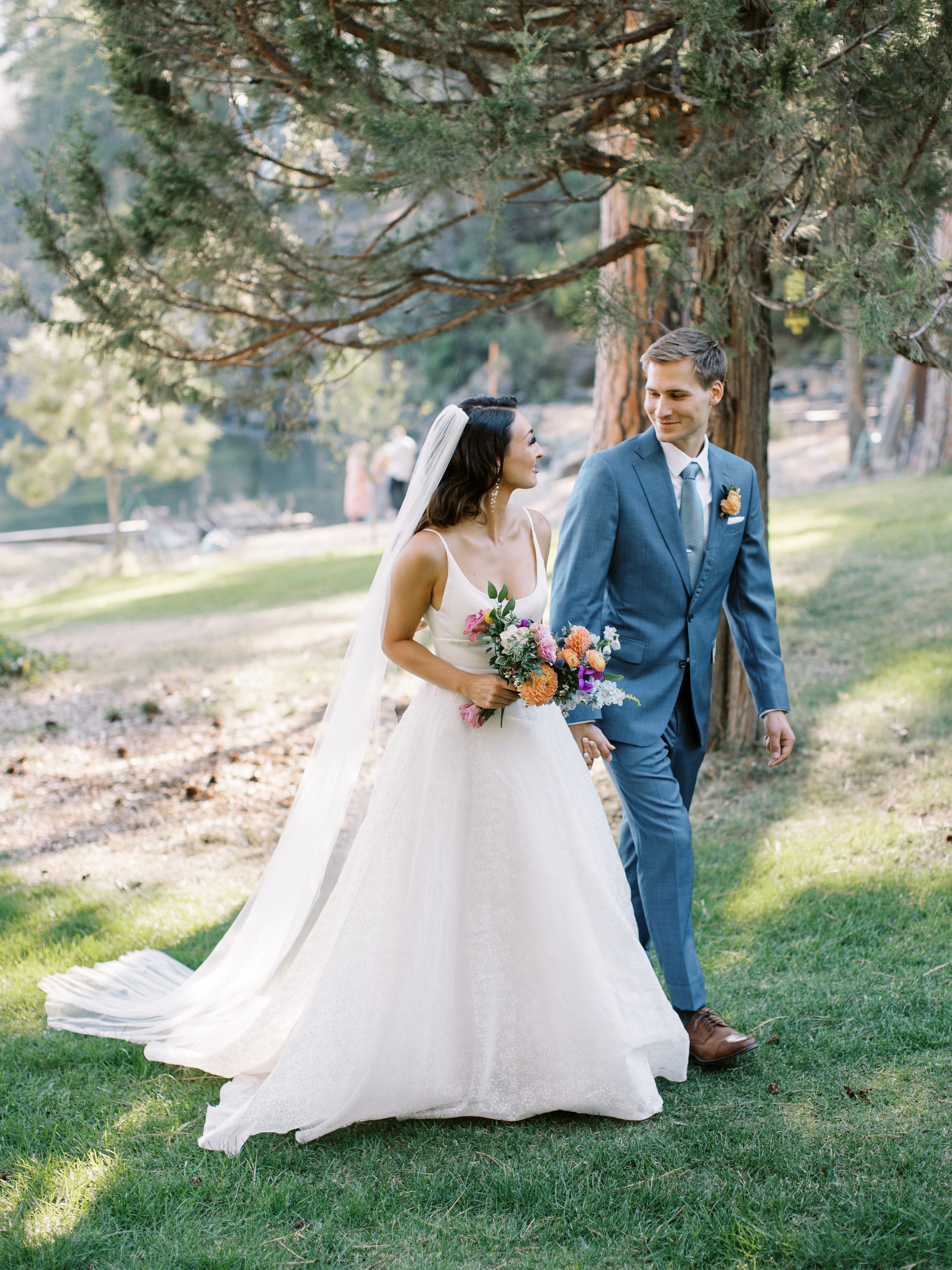 Jeune couple marchant dans la nature dans leurs tenues de mariage