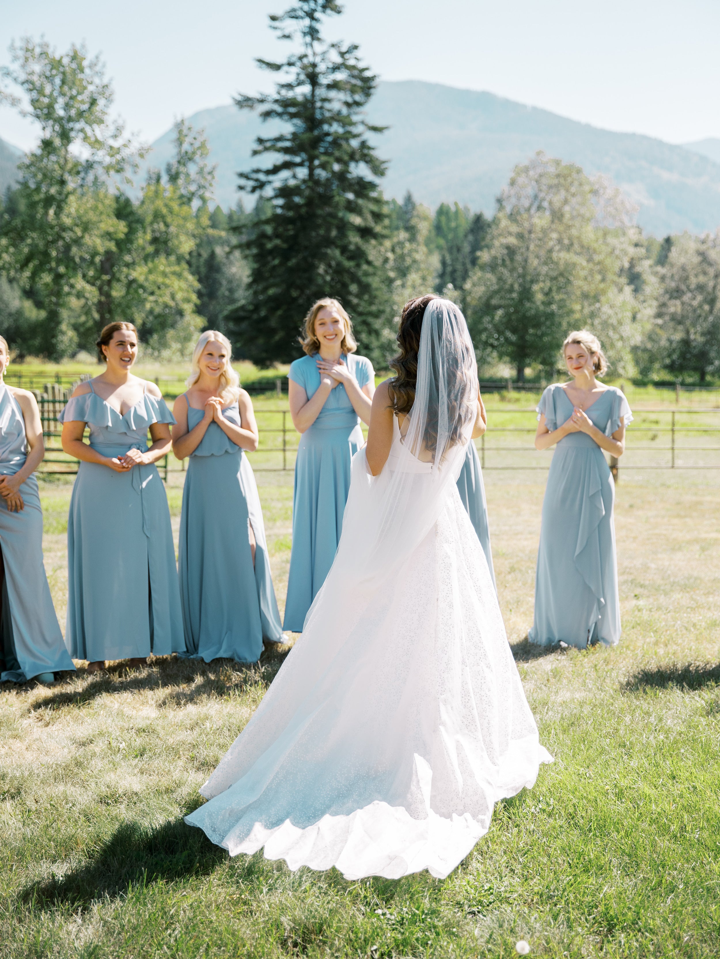 Jeune mariée en robe blanche devant ses demoiselles d'honneurs en tenue de cérémonie bleue