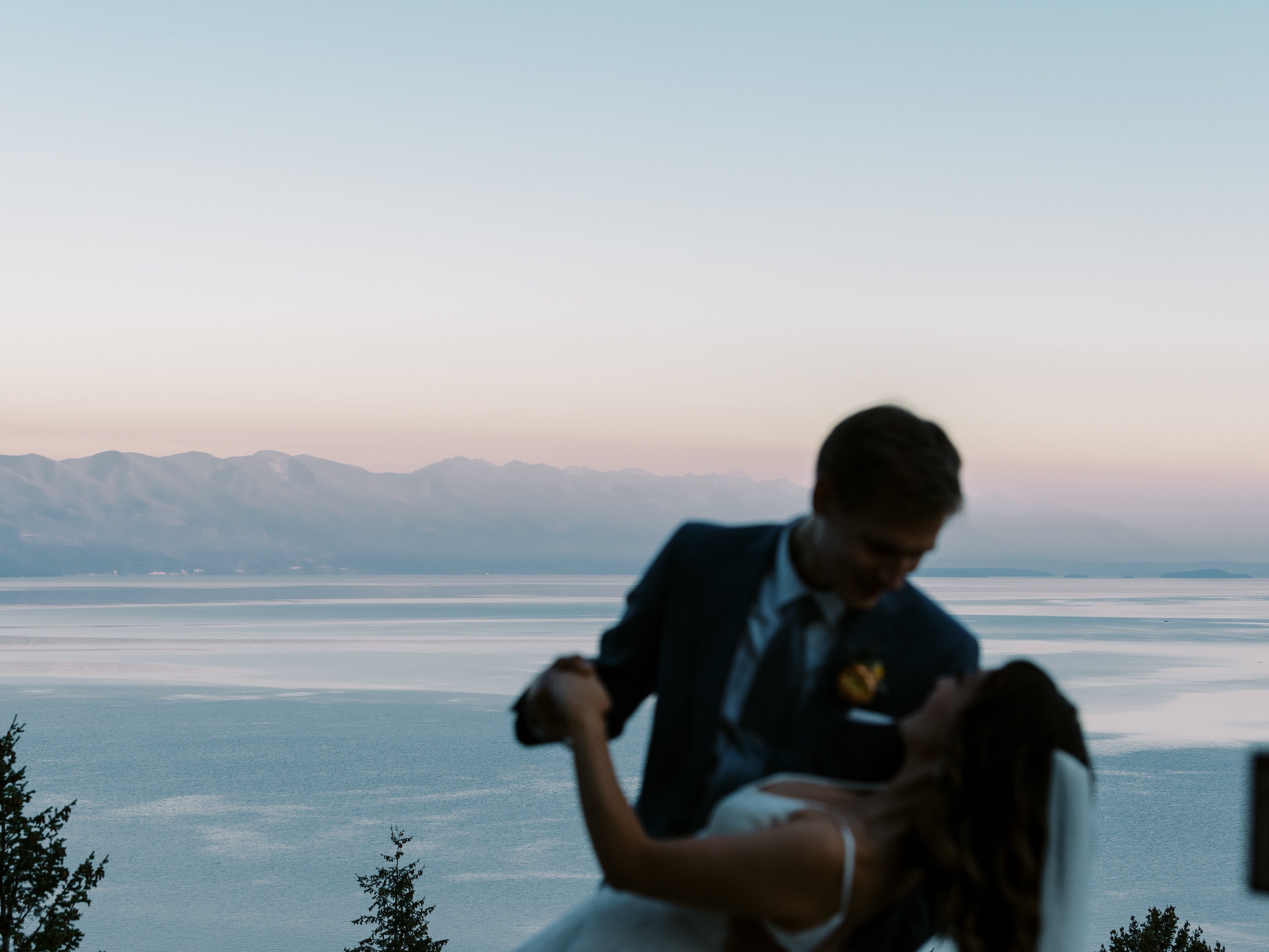 Coucher de soleil avec en premier plan le couple de marié qui danse en souriant