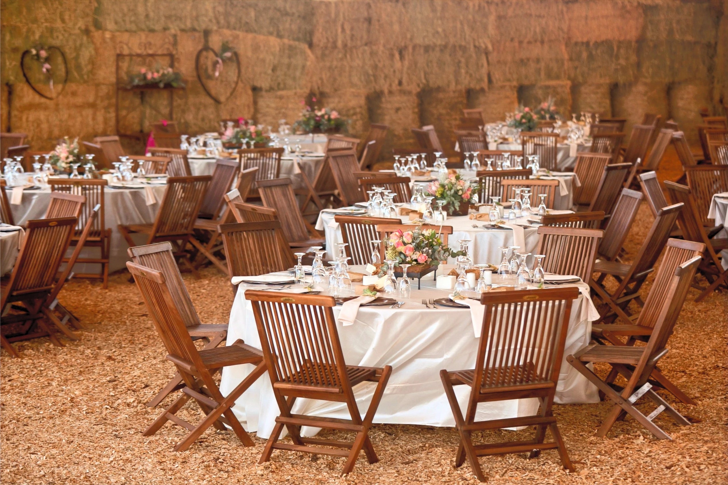 Salle de réception pour le mariage avec des tables rondes et des bouquets au centre des tables