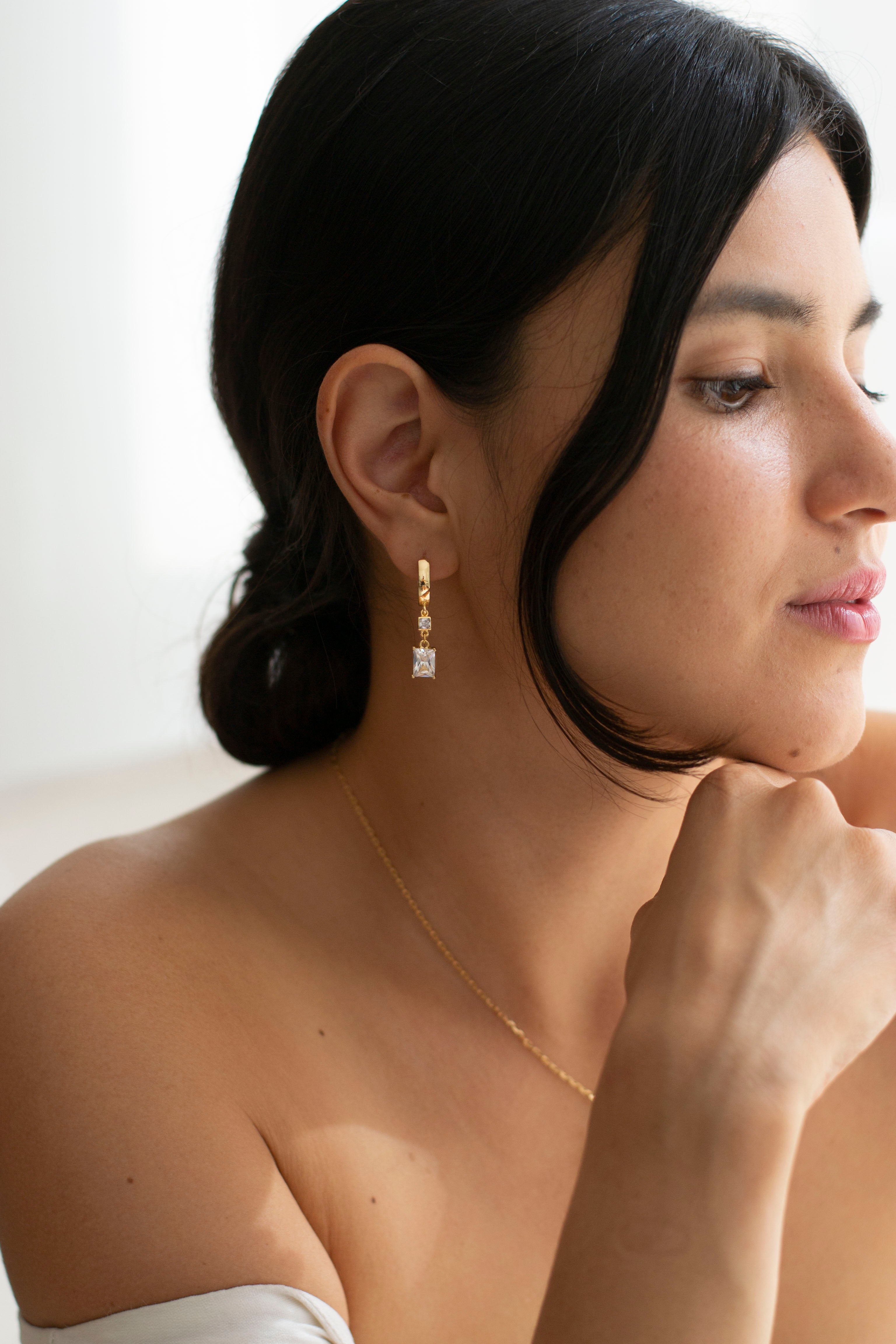 boucles d'oreilles pour mariage style vintage avec des cristaux carré porté par une mariée avec un chignon bas