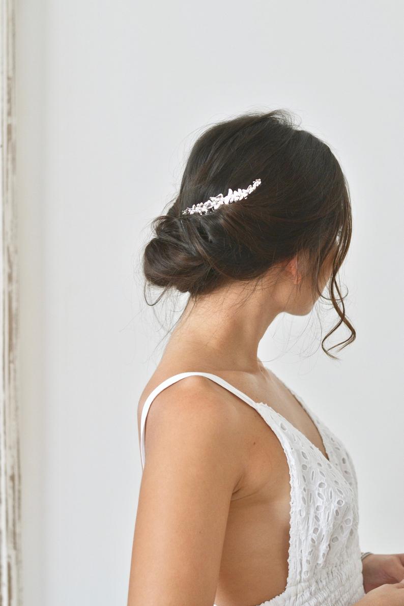 coiffure de mariage avec un peigne de mariée sur un chignon bas